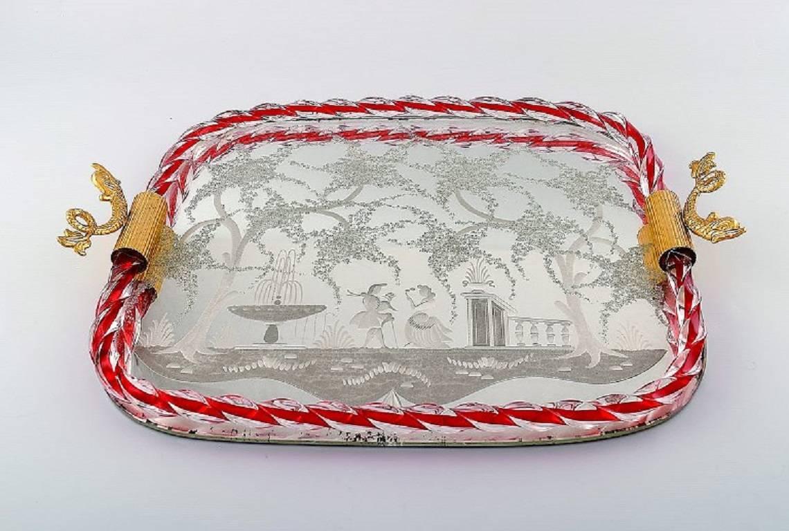 Murano, Italy, art glass rectangular tray with mirror coating, floral pattern with galant scene, two gold-colored metal grips on the side formed as fish.
Measures: Length approximate 44 cm (with handle), width approximate 33 cm.
In perfect