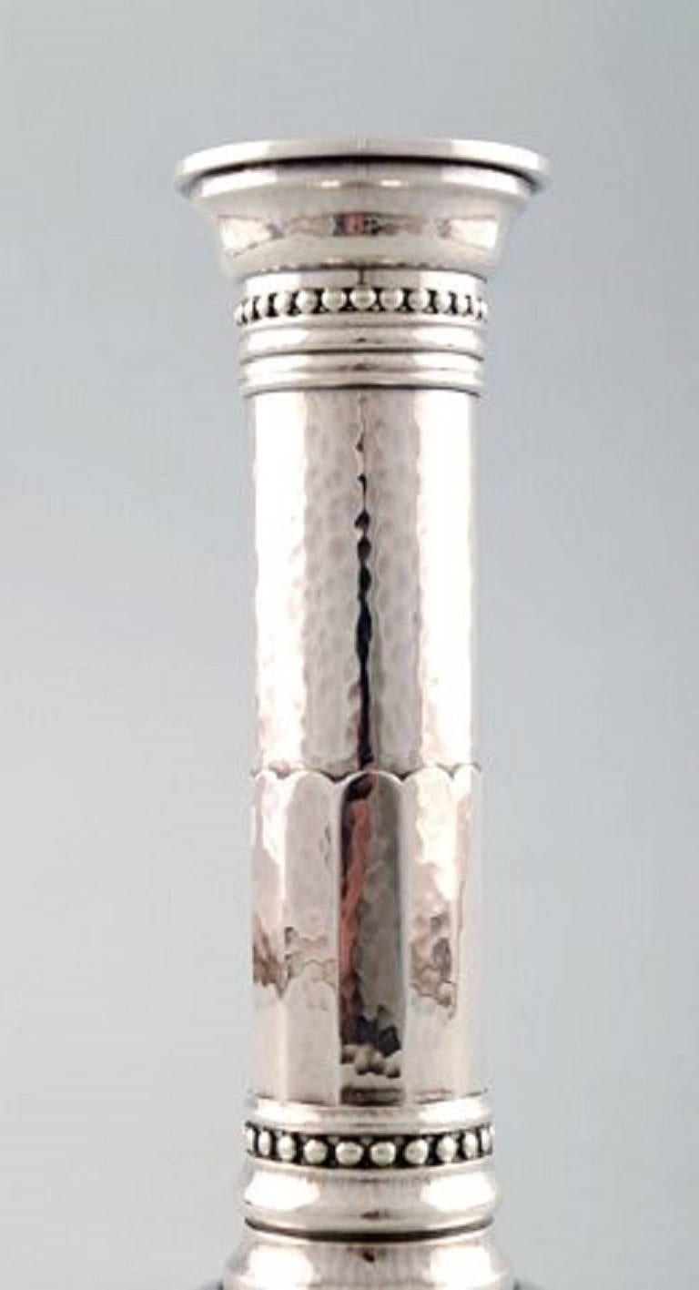 Johan Rohde: Candlestick of hammered sterling silver on round foot.
Georg Jensen 1945-1977.
Design 454 A.
Weight 375 grams.
Measures: Height 15.5 cm.
In perfect condition.