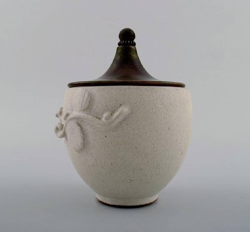 Arne Bang (1901-1983). Jar with lid of glazed stoneware with foliage in relief, lid of patinated bronze.
Signed in monogram, AB and design no. 181.
Measure: Height 12 cm x diameter 9 cm.
In perfect condition.