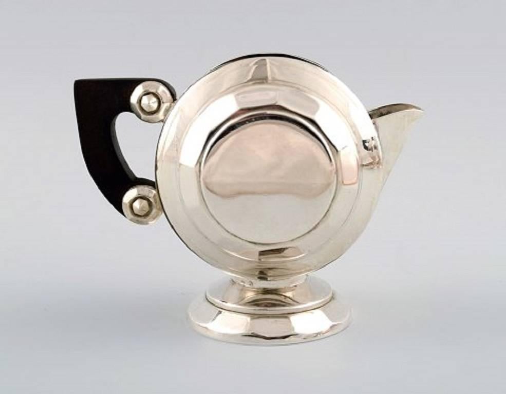 Exclusive and complete Art Deco coffee / tea service, large tray on feet, silver plated. Designed by Christian Fjerdingstad for Christofle (Gallia.)
Handles of dark ebony.
Including two pots, sugar / creamer on tray.
Beautiful original