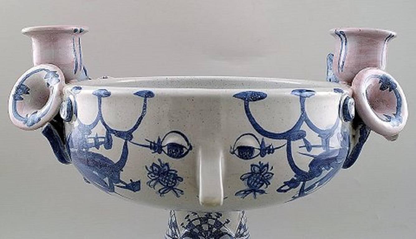 Bjorn Wiinblad 1918-2006. Centerpiece / vase, model 'Eva' of blue glazed earthenware in the shape of a woman's head, ornamented with candlesticks on the sides.
Signed in monogram BW-72, dessin V14.
Measures 30 cm. x 30 cm.