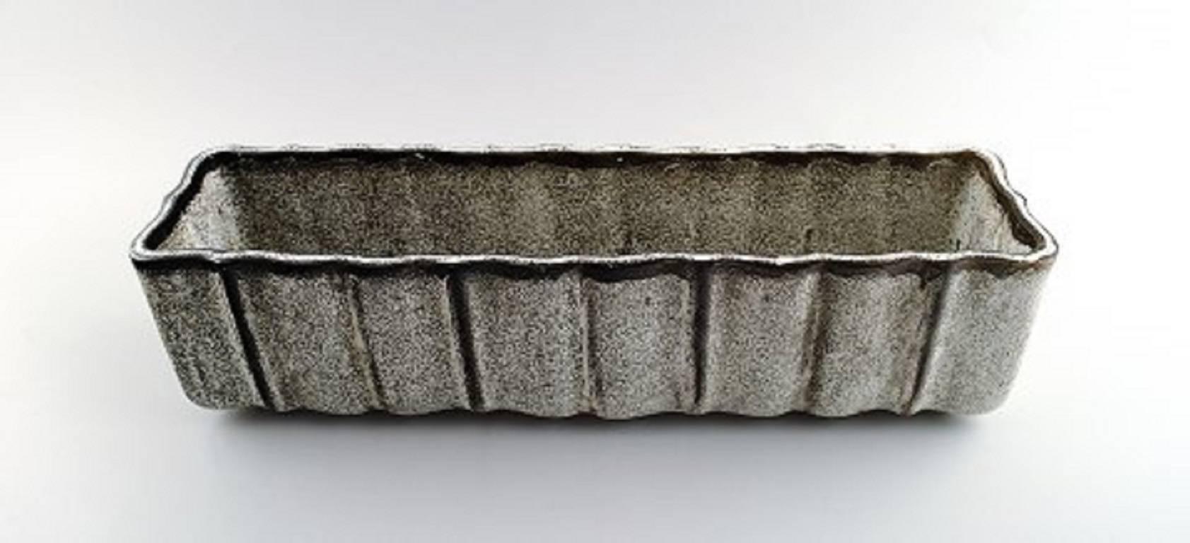 Kähler, Denmark, glazed stoneware large-jardinière / flowerbowl, 1930s.

Designed by Svend Hammershøi. Glaze in black and gray.

Measures: 40 x 10.5 x 9.5 cm.

Hallmarked.

In perfect condition.