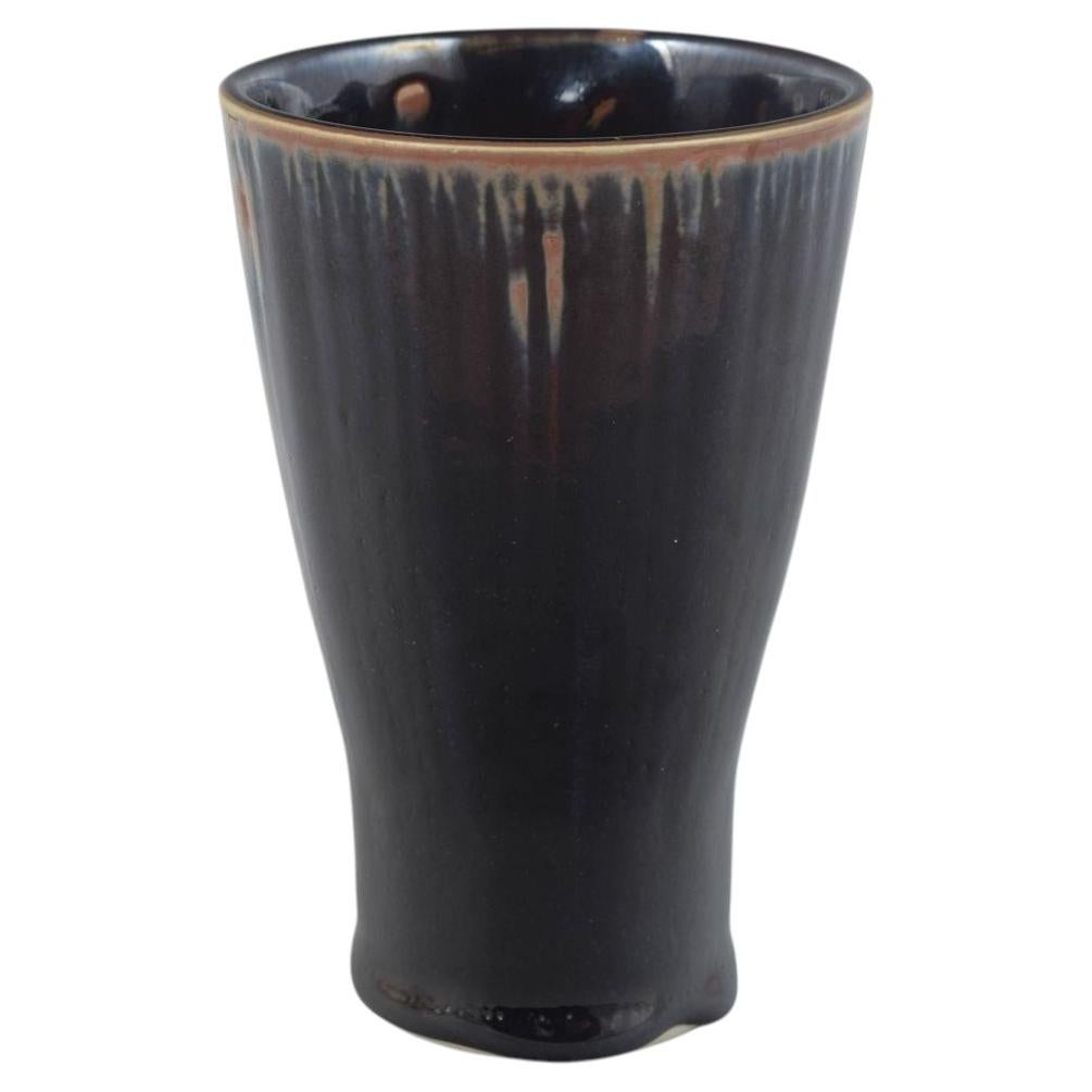 Rörstrand. Conical stoneware vase with dark glaze. Mid-20th C.