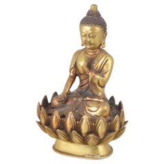 Seated Buddha figure in gilt bronze with one hand raised. Asia, 19th C
