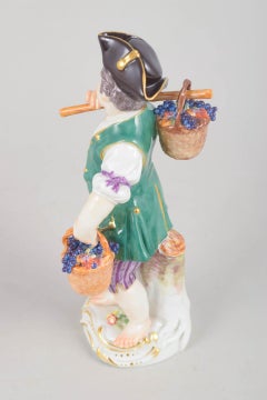 Meissen, Germany. Porcelain figurine of boy with baskets of grapes. Early 20th C