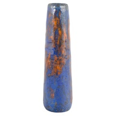 European studio ceramicist. Tall and slender vase in shades of blue and orange.
