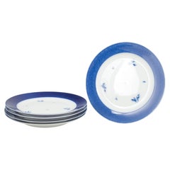 Royal Copenhagen. Cinco platos grandes de porcelana con el borde de color azul intenso. Años 50
