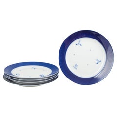 Royal Copenhagen. Cinco platos grandes de porcelana con el borde de color azul intenso. Años 1960