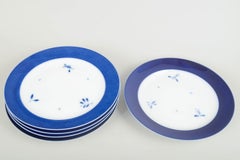 Royal Copenhagen. Cinco platos grandes de porcelana con el borde de color azul intenso. Años 1960