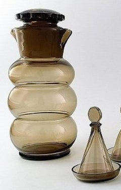 Jacob Bang: "Helan går". Brown glass decanter and ten schnapps glasses