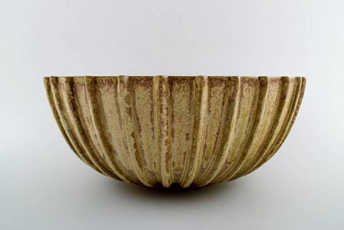 Arne Bang. Stoneware bowl with fluted corpus decorated with brown / ocher speckled glaze.
Signed in monogram. No. 189.
Diameter 26 cm. Height 12 cm.
In perfect condition.