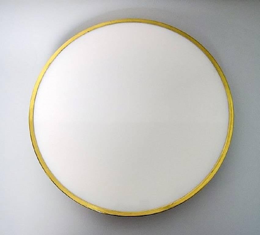 Arne Jacobsen. 1902-1971. Two ceiling or wall lamps.
Model Munkegaard of white opal glass, lace list in brass.
Manufactured by Louis Poulsen.
Measures: Diameter 45 cm.
In good condition.