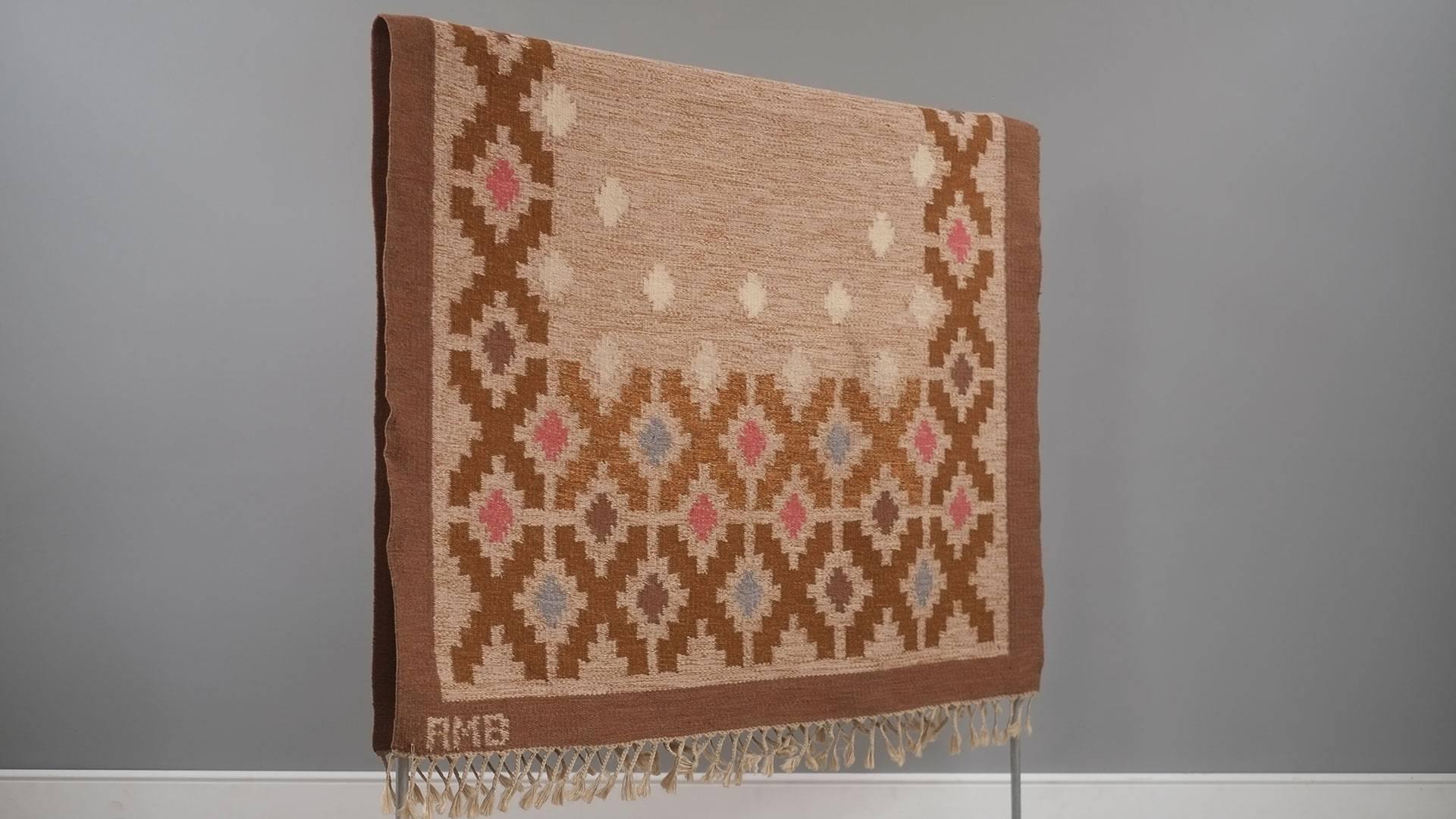 Amazing vintage Swedish flat-weave rug by Anne-Marie Boberg. This example with beige ground with vivid pink and baby blue motifs. Handwoven in wool and signed AMB to the right hand corner. Great piece.