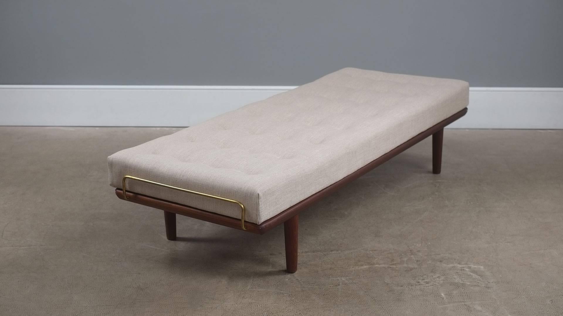 Superb daybed in teak designed by Hans Wegner for Getama, Denmark. This example with fully refurbished original sprung mattress and beautiful new upholstery including buttons covered in contrasting cognac leather.