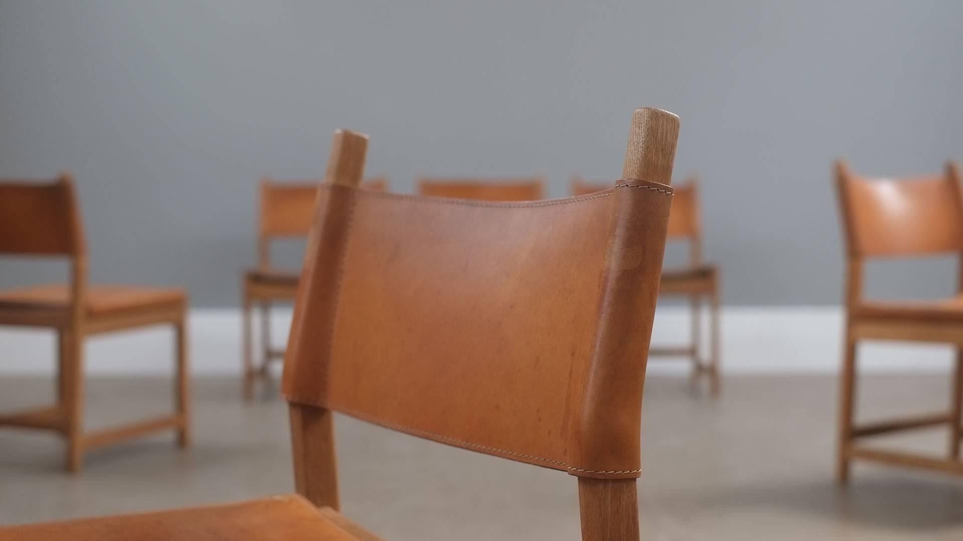 Amazing set of six hunting chairs in solid oak with saddle leather seats and backs designed by Kurt Ostervig, Denmark. Very thick leather with fabulous patina. Wonderful and rare set of chairs.