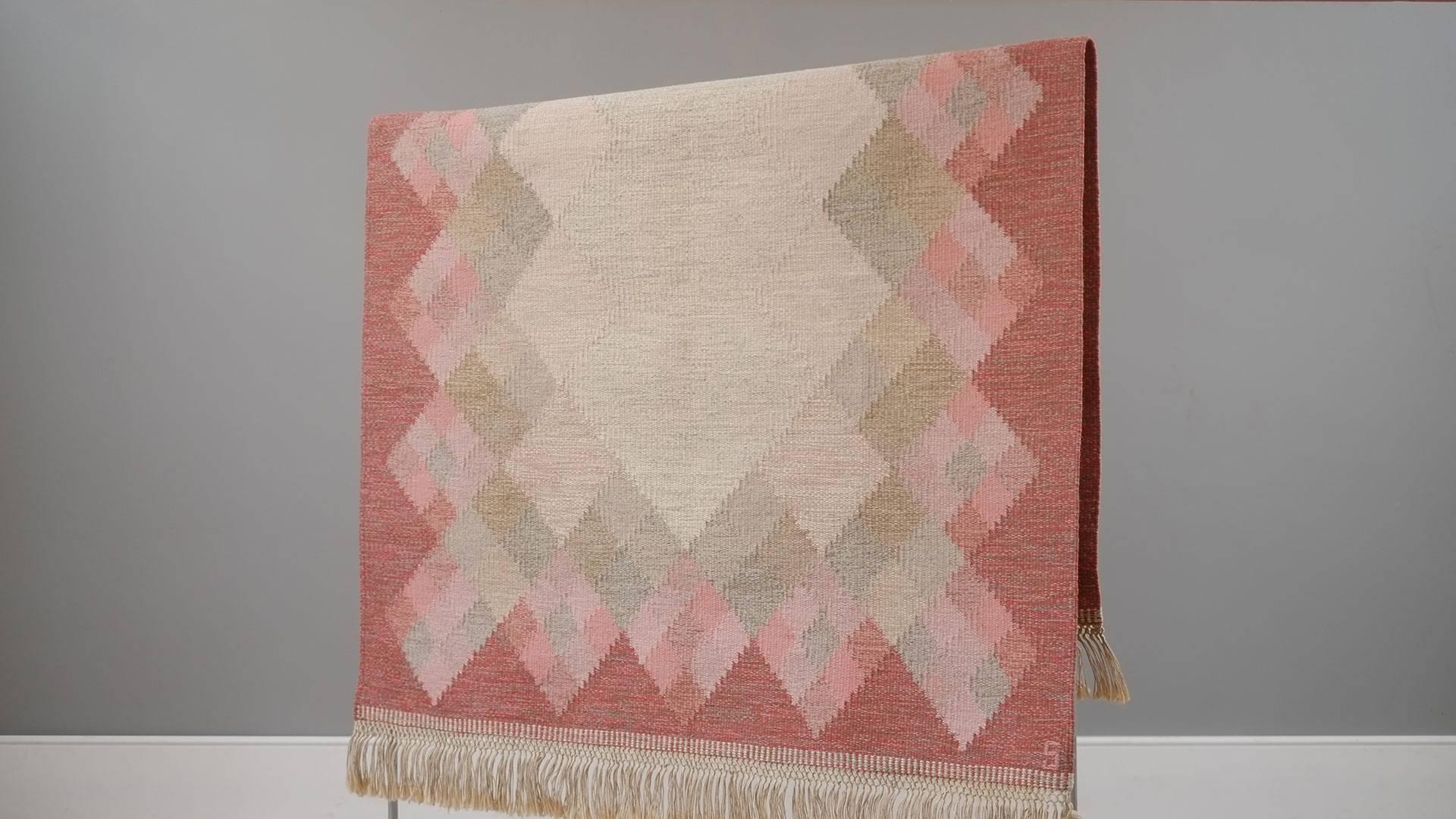 Beautiful vintage Swedish flat-weave rug in reds, pinks, and beiges. Classic handwoven piece in wool by Britta Svefors and signed S. Wonderful quality and in super fine condition. Great piece.