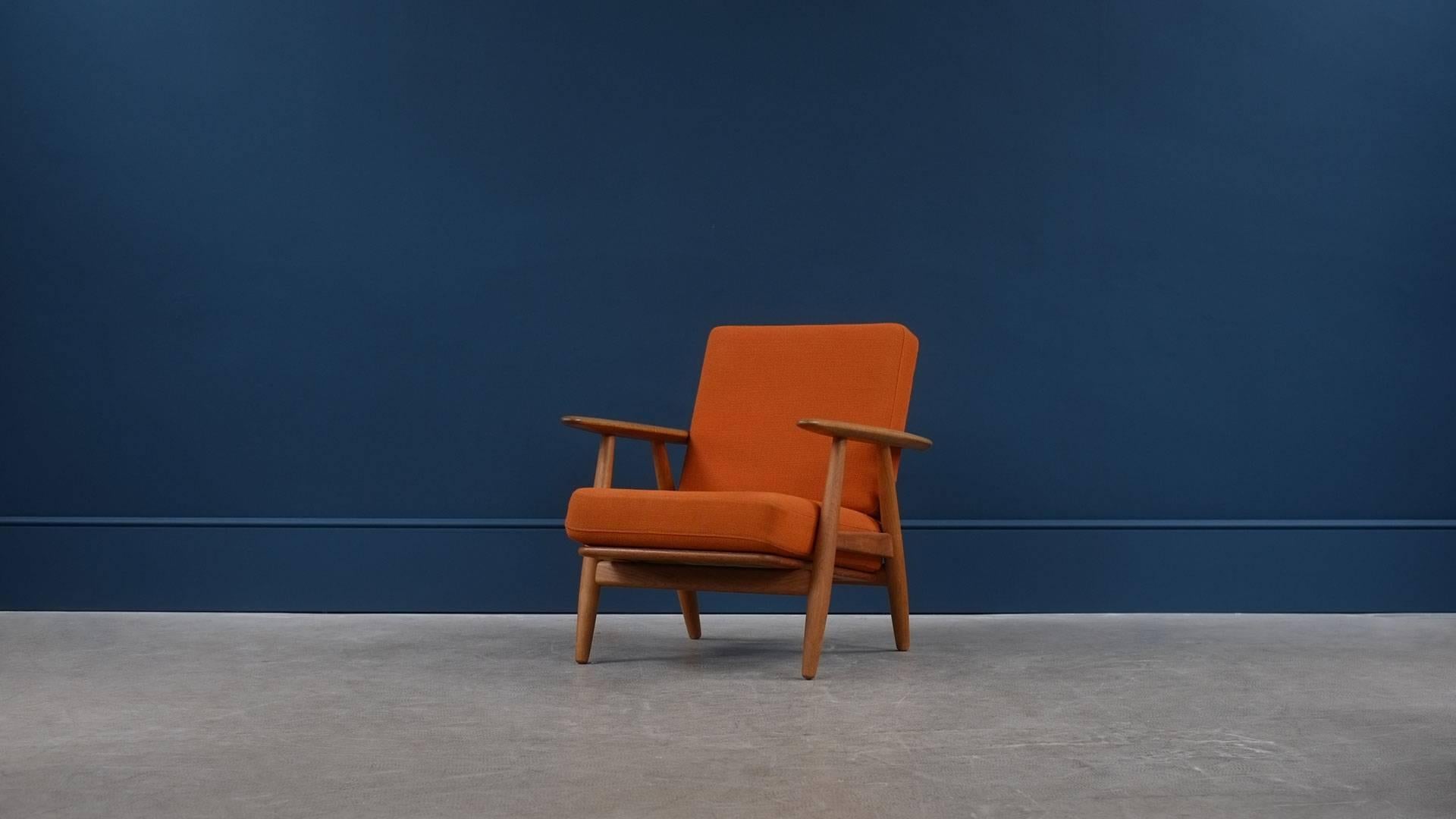 Wonderful GE240 cigar chair by Hans Wegner for GETAMA, Denmark. Very figured solid oak frame with original sprung cushions and orange fabric. New upholstery options available.