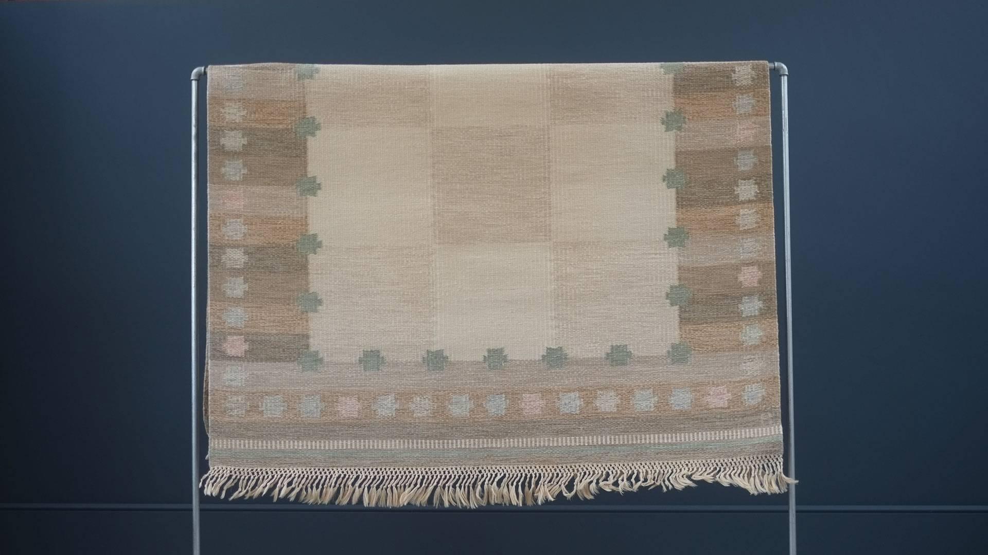 Amazing vintage Swedish flat-weave rug by sought after designer Anna Johanna Angstrom. This example in muted colors with pastel reds pinks and greens. Handwoven in wool and signed A to the right hand corner. Great piece.