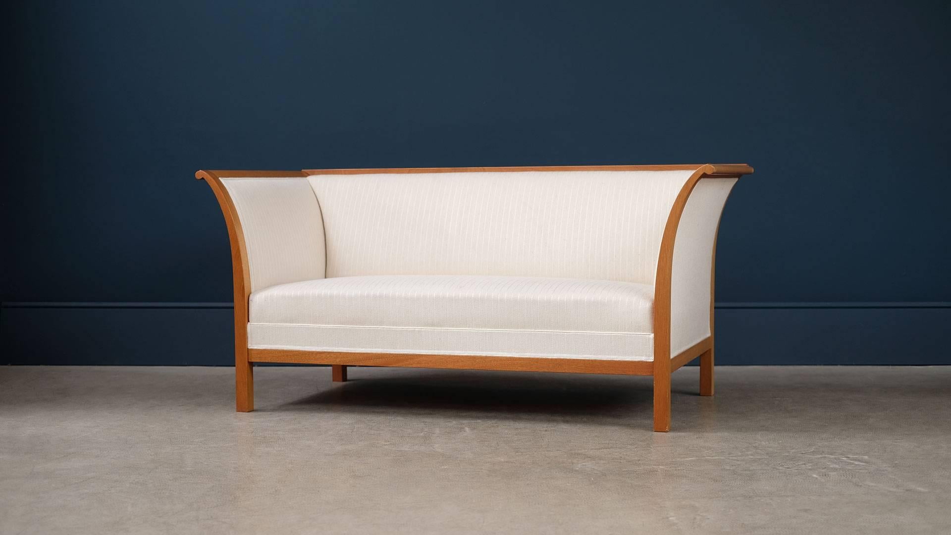 Super elegant and beautiful two-seat sofa designed by Fritz Henningsen for cabinet maker Rud Rasmussen, Denmark. Rare example of this ultra high quality sofa in sculptural solid mahogany with reindeer hair and silk upholstery.