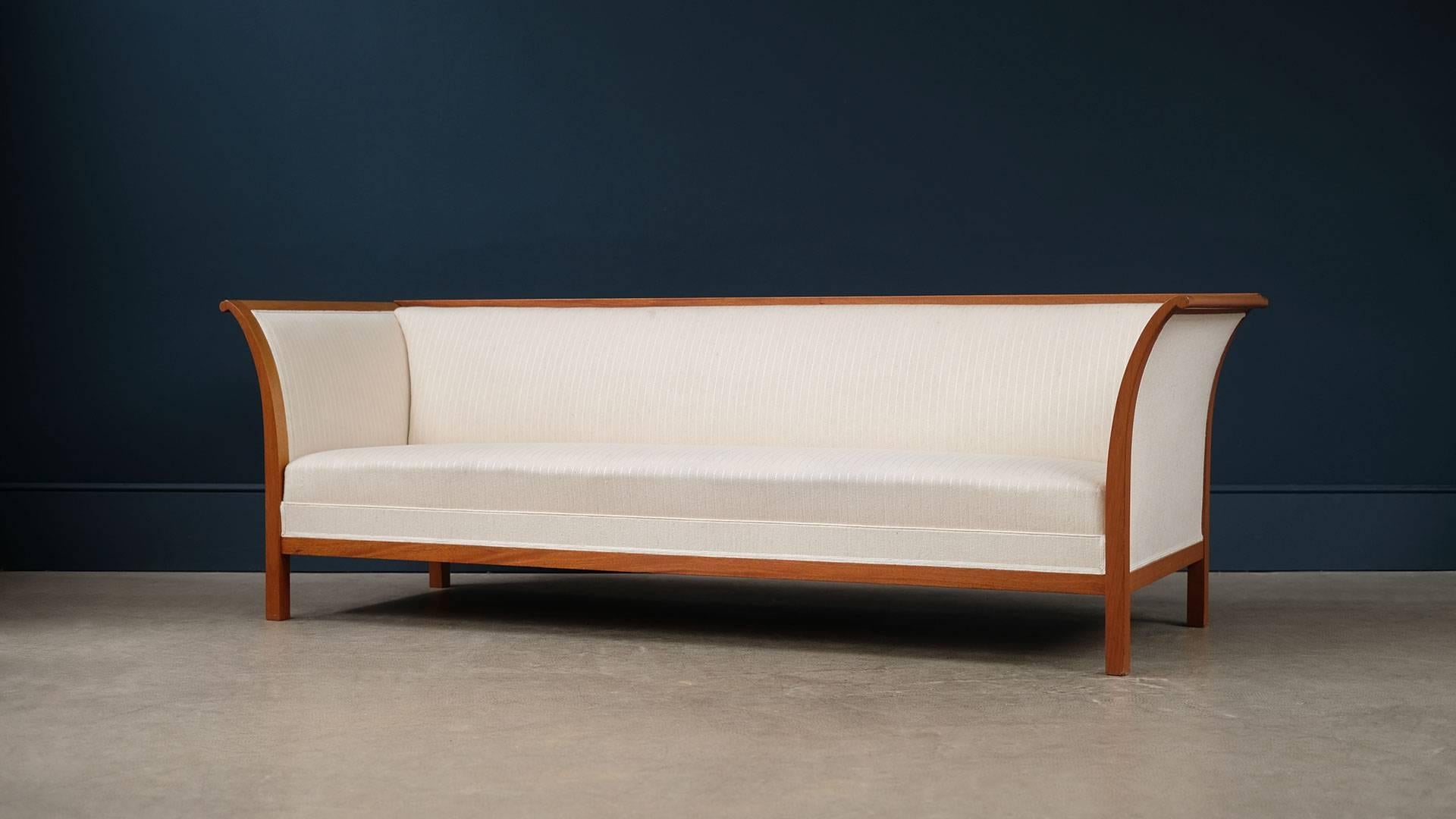 Super elegant and beautiful three seat sofa designed by Fritz Henningsen for cabinet maker Rud Rasmussen, Denmark. Rare example of this ultra-high quality sofa in sculptural solid mahogany with reindeer hair and silk upholstery.
  