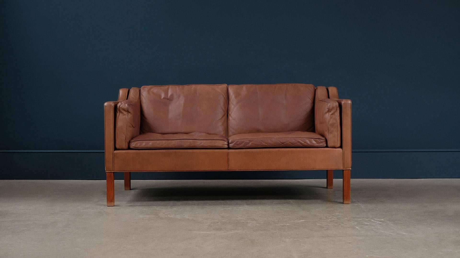 The real thing, fantastic example of the Classic two-seat sofa designed by Borge Mogensen for Fredericia, Denmark, model 2212. Unsurpassed quality and in beautiful brown leather with patina and teak legs. Great vintage example.