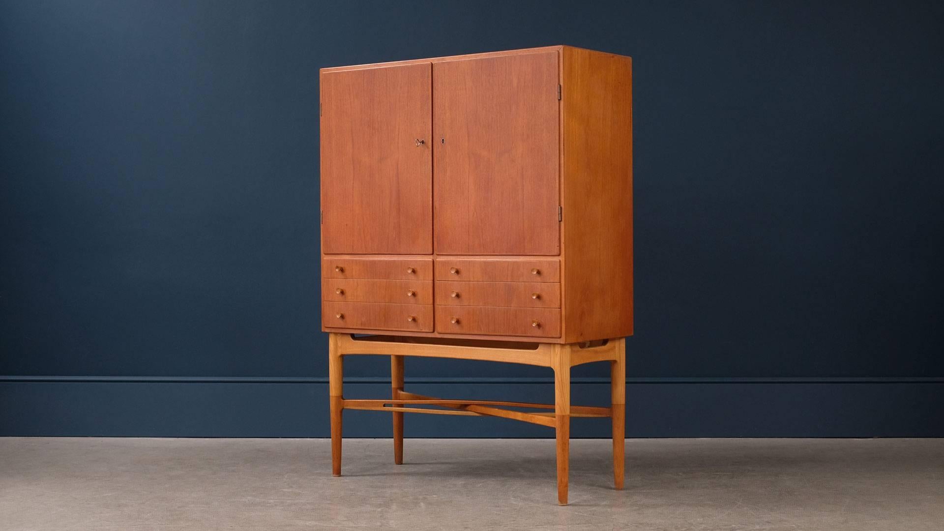 Ultra high quality and super elegant Swedish cabinet in teak with contrasting ash legs. Beautiful piece of Scandinavian design with amazing details – the stretcher is wonderful.