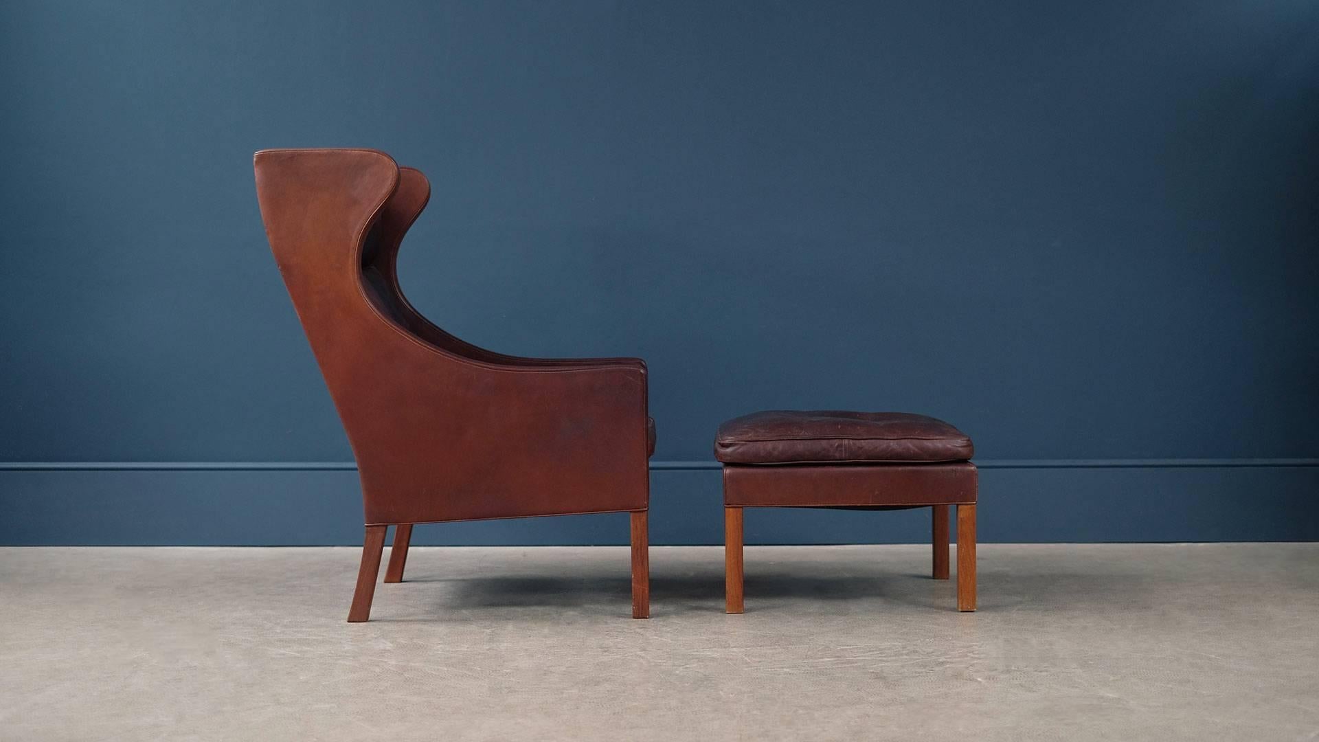 Amazing example of Borge Mogensen classic 2204 high back armchair and 2202 footstool for Fredericia, Denmark. This early chair and stool is in wonderful and super rare thick brown analine leather with perfect patina.
