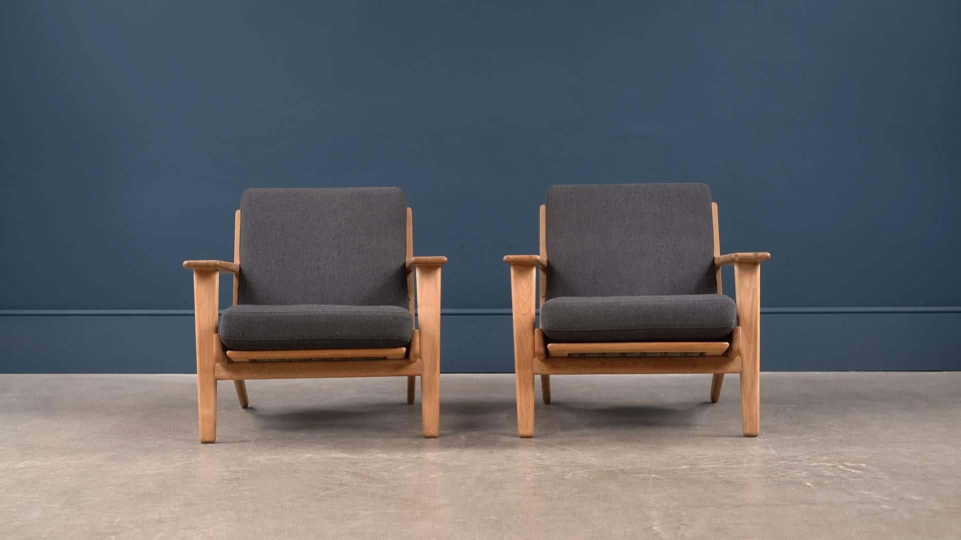 Fantastic GE290 lounge chairs designed by Hans Wegner for Getama, Denmark. Solid oak frames with original sprung cushions with beautiful charcoal fabric. Other upholstery options available. 