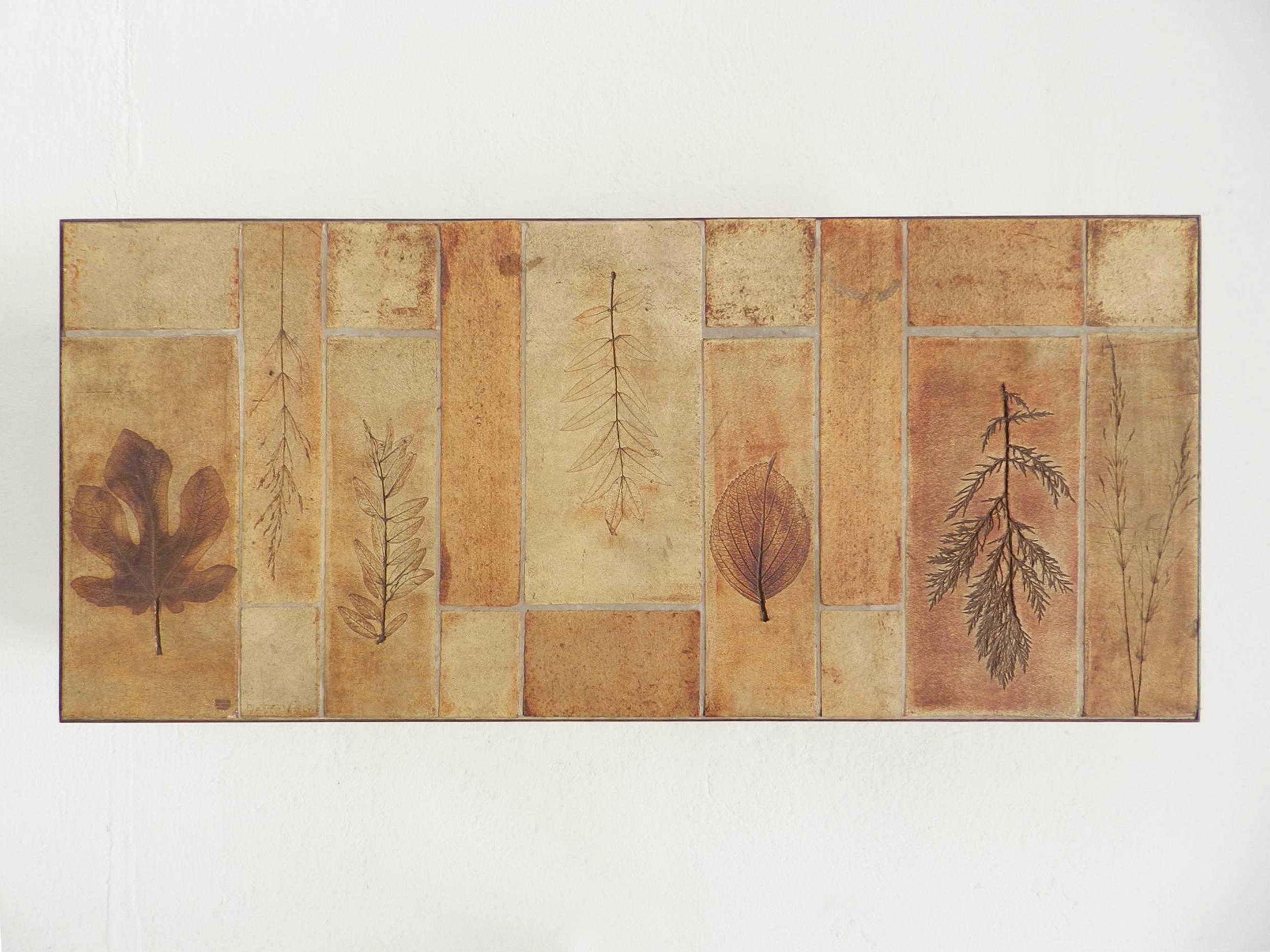 Low table from the Garrigue series by the French master ceramist Roger Capron in Vallauris. Ceramic tiles with an impressed leaves decor and metal frames. Trademark stamped on a glazed tile.