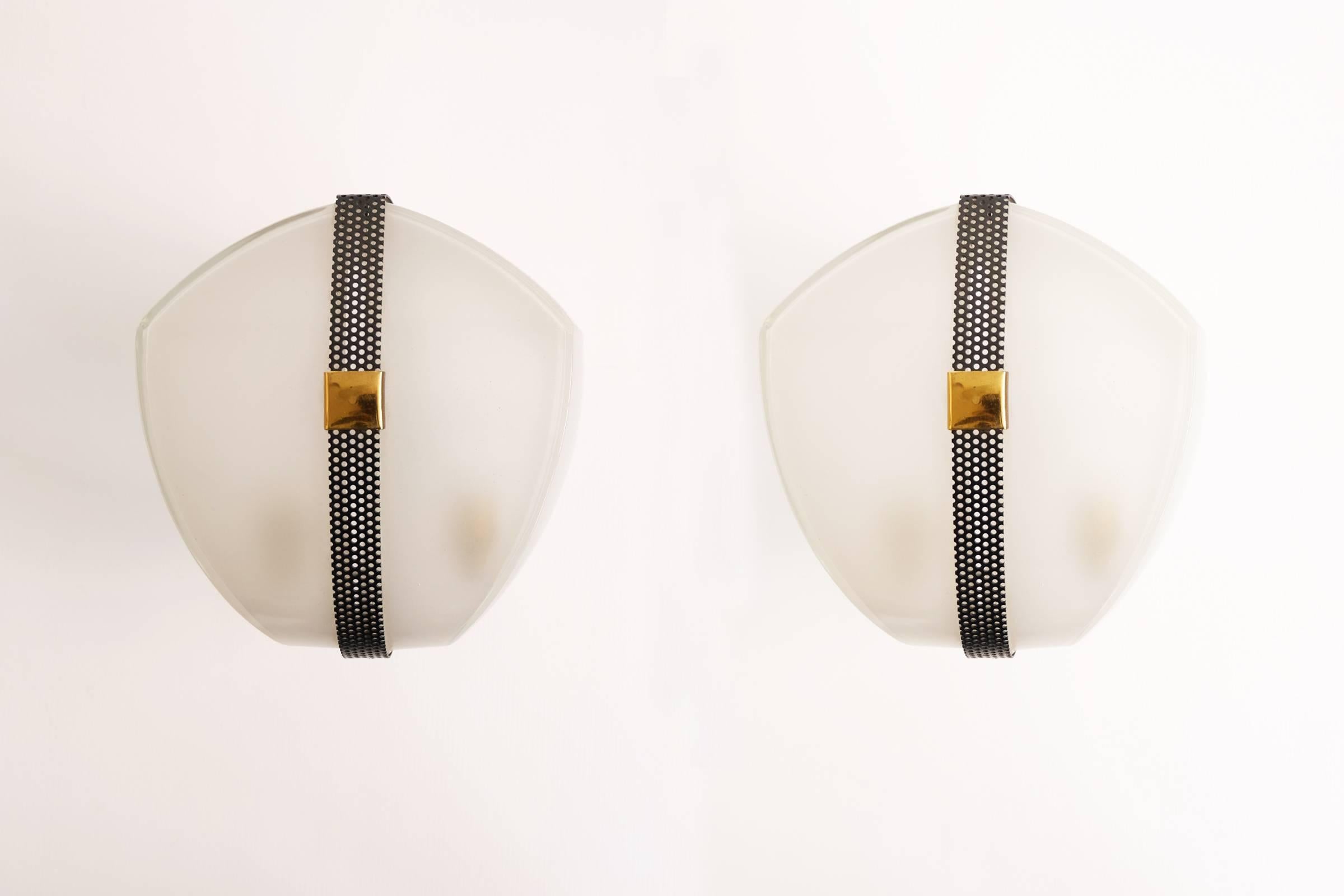 Perforated metal and brass details pair of sconces in the style of Stilnovo.