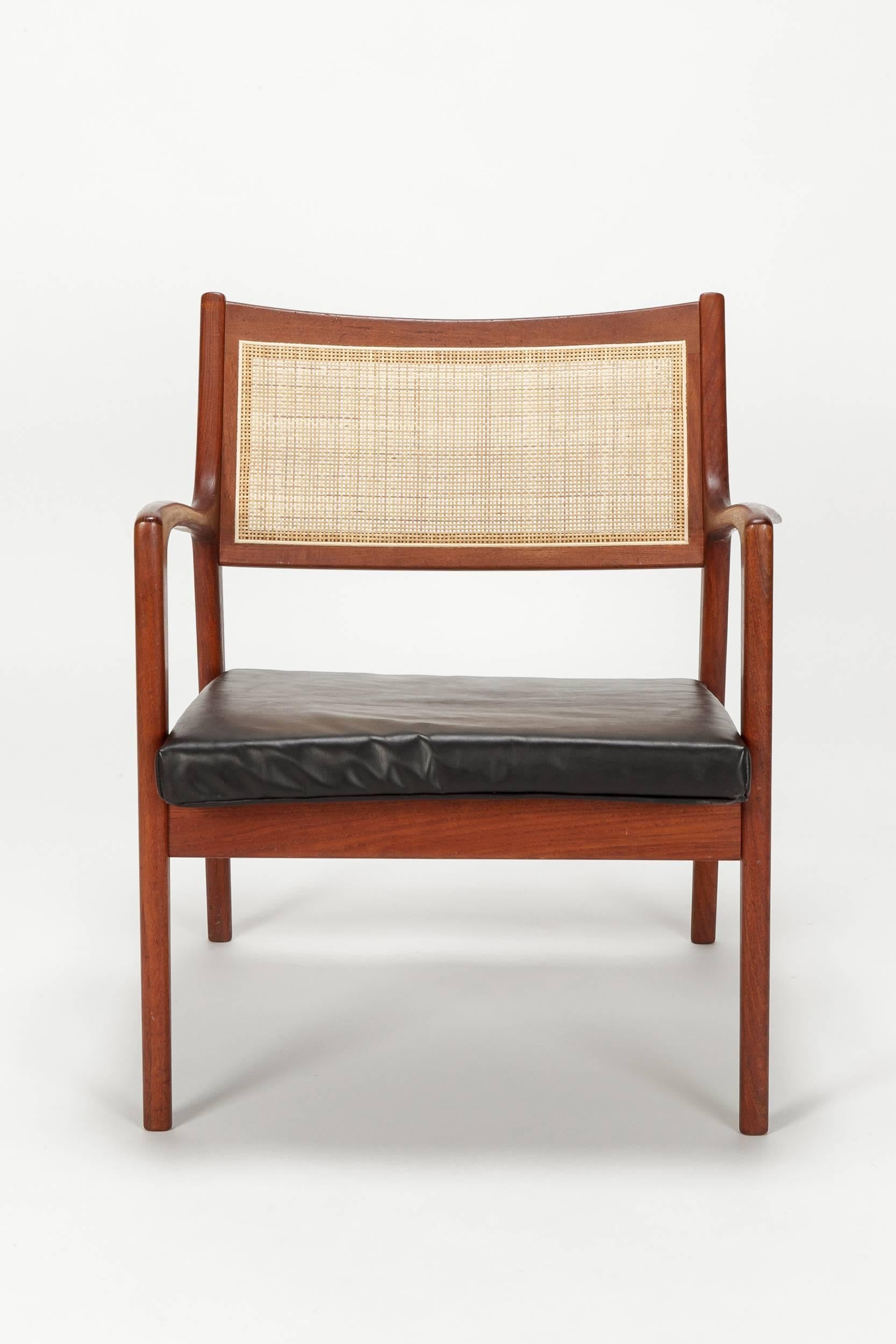 Wonderful Karl Erik Ekselius chair model F139 designed in 1955 and manufactured by JOC Vetlanda in Sweden. The frame is made of solid teak, organically shaped armrests, woven cane backrest and a new covered leather seat cushion. The cane webbing was