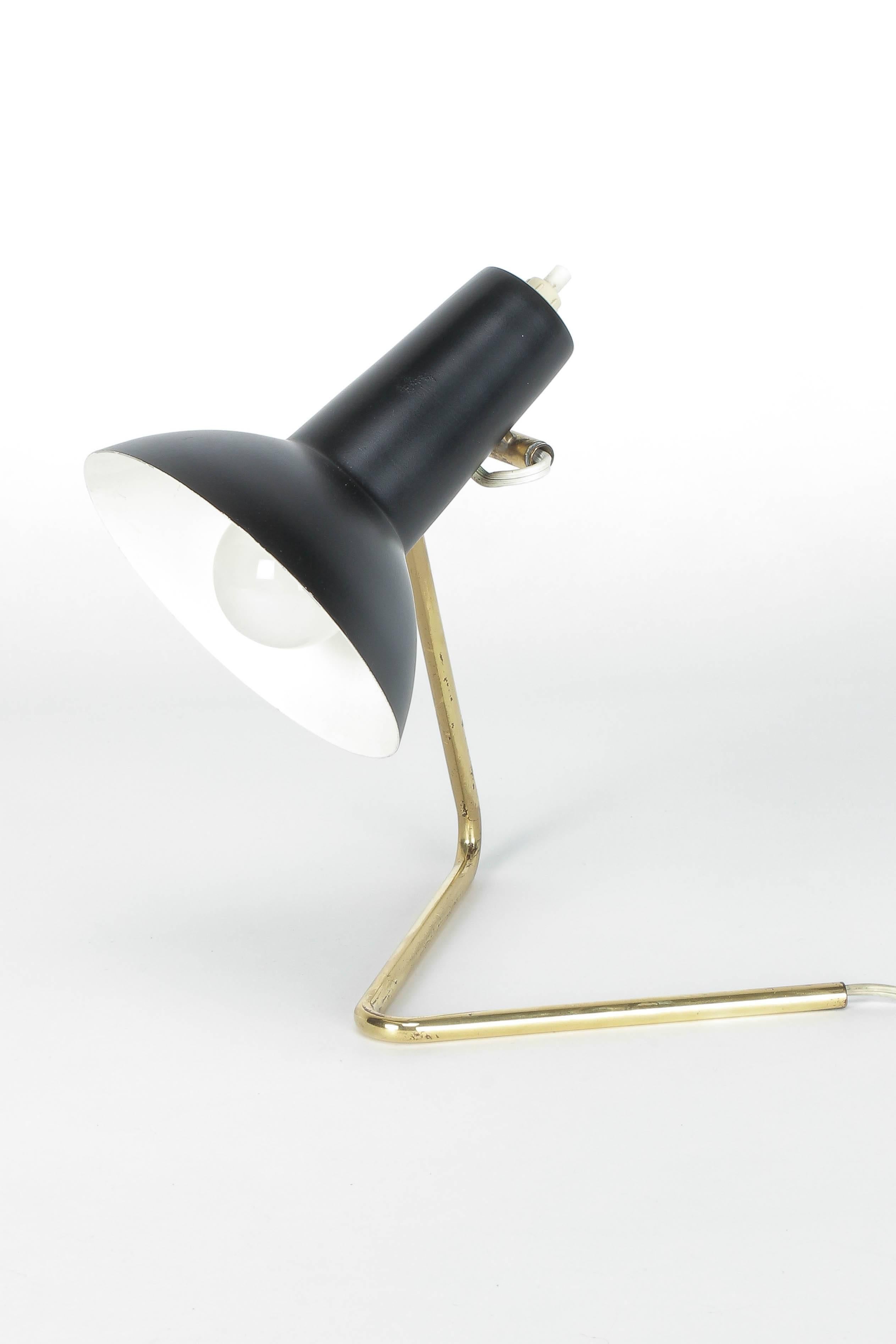 An incredibly rare Gino Sarfatti lamp, model 551 manufactured by Arteluce in 1952. Black lacquered shade, rotates on a horizontal plane by friction joint. Structure in polished brass tubing, can be positioned on the desk or wall. All parts are in