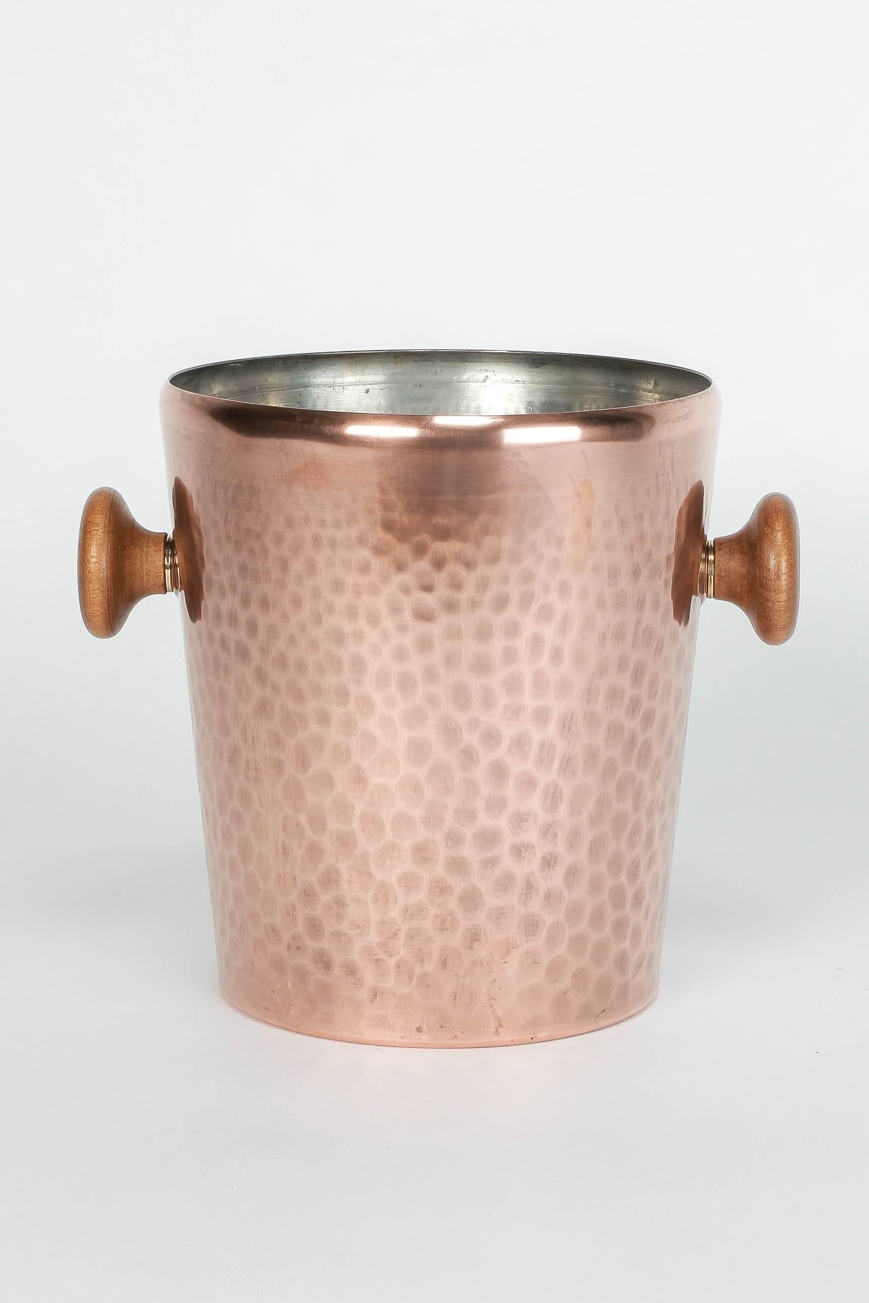 High-end copper ice bucket manufactured by the Swiss producer Stöckli Netstal in the 1950s. Hammered copper with solid walnut handles and brass details.