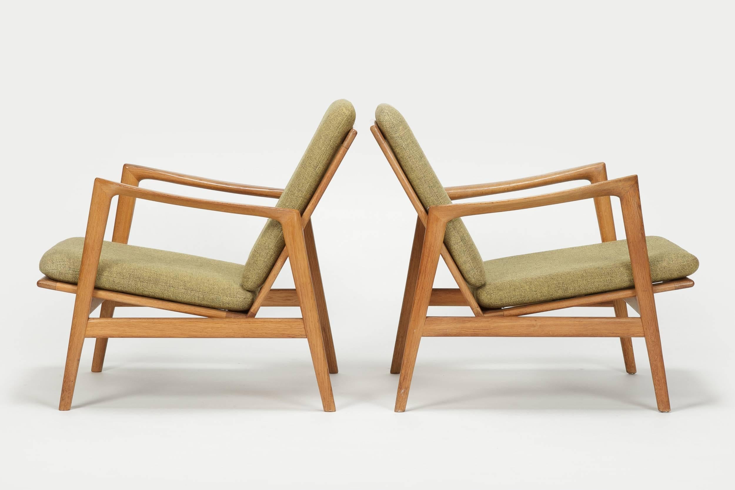 Beautiful pair of Hans Olsen lounge chairs manufactured in the late 1950s by Juul Kristiansen in Denmark. Very elegant shape of frame with beautiful crafted details, made of solid oak with the original upholstery in a light green mixed wool fabric.