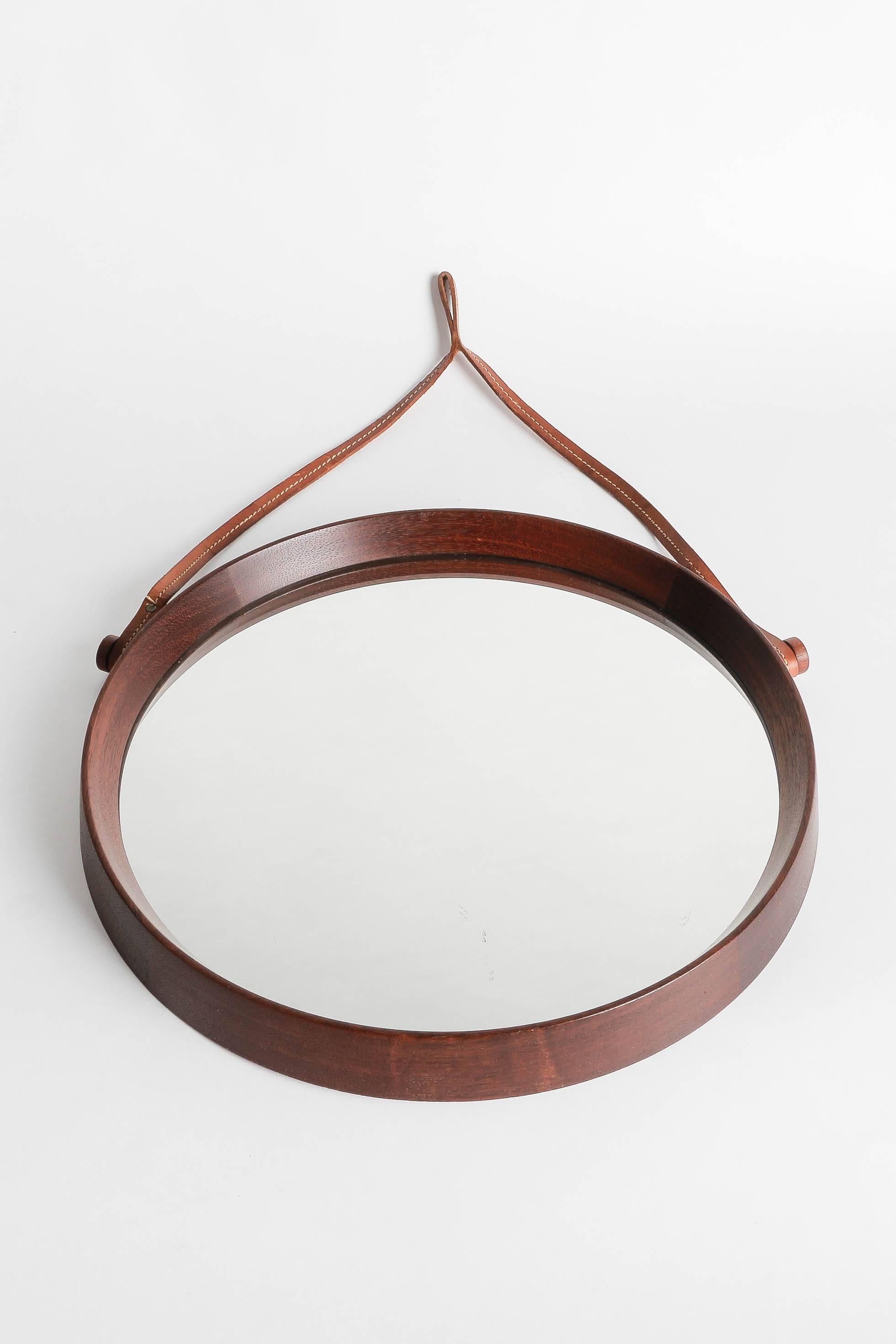 Beautiful Swedish mirror by Uno & Östen Kristiansson in solid teak with a leather strap to hang it on the wall.