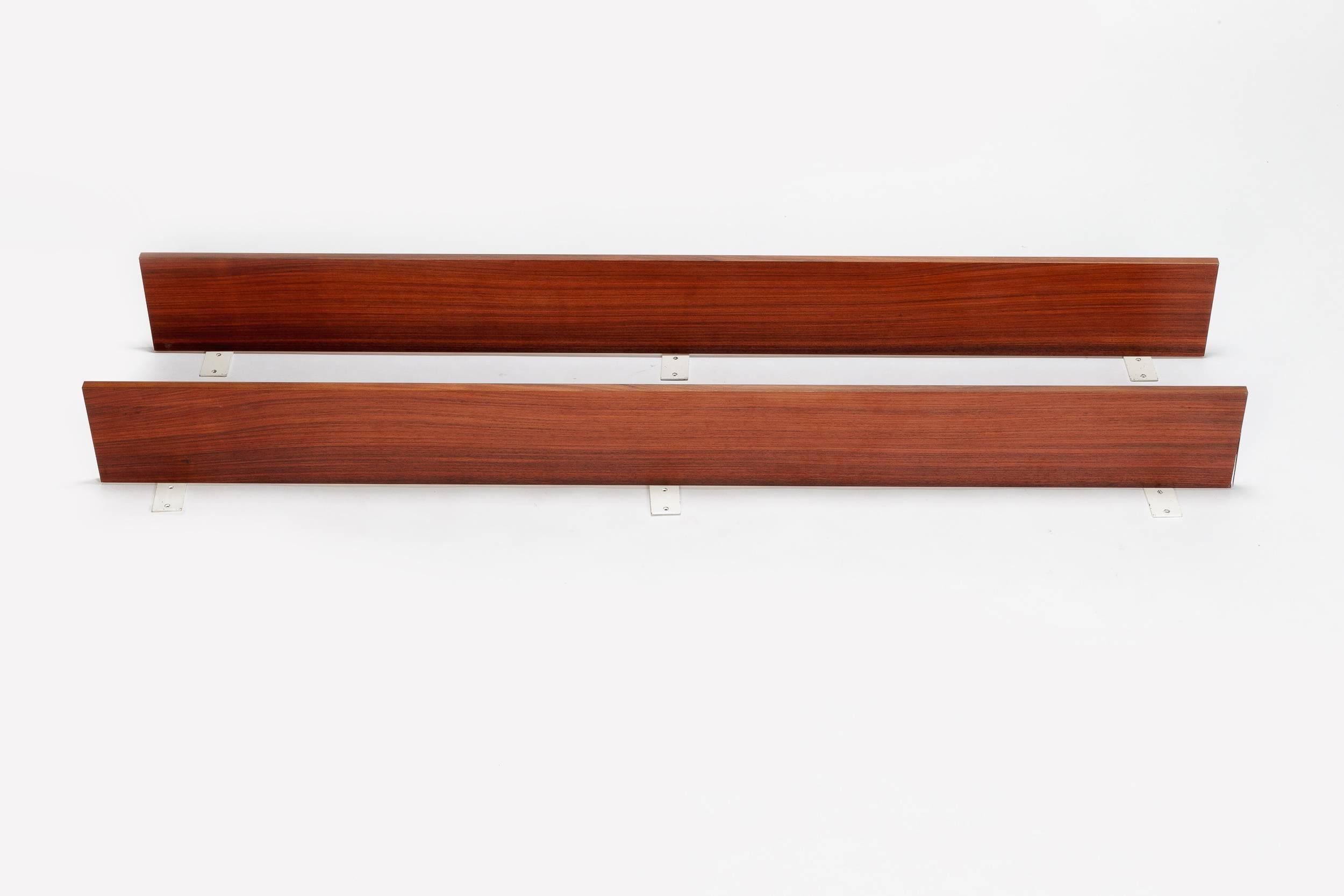 Pair of Swiss design Dieter Waeckerlin shelves from the 1960s, manufactured by Idealheim in Switzerland. Very high quality craftsmanship with a sophisticated system. Made of white lacquered metal wall mounts and shelves of rosewood veneer.