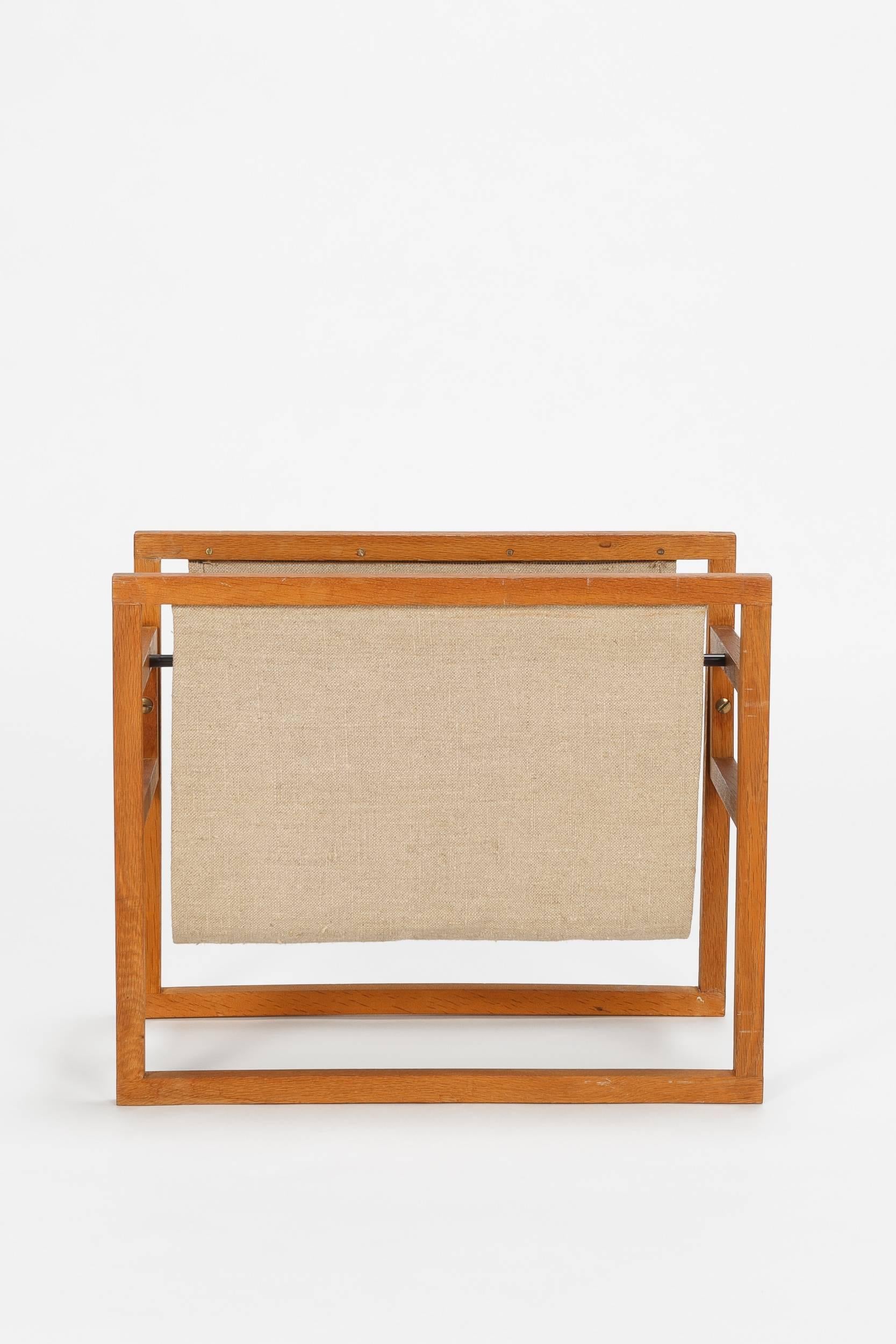 Wonderful Henning Wind-Hansen magazine rack manufactured by Sika Møbler in the 1960’s in Denmark. Solid oak with a storage for magazines and news made of linen. Nicely hand crafted.