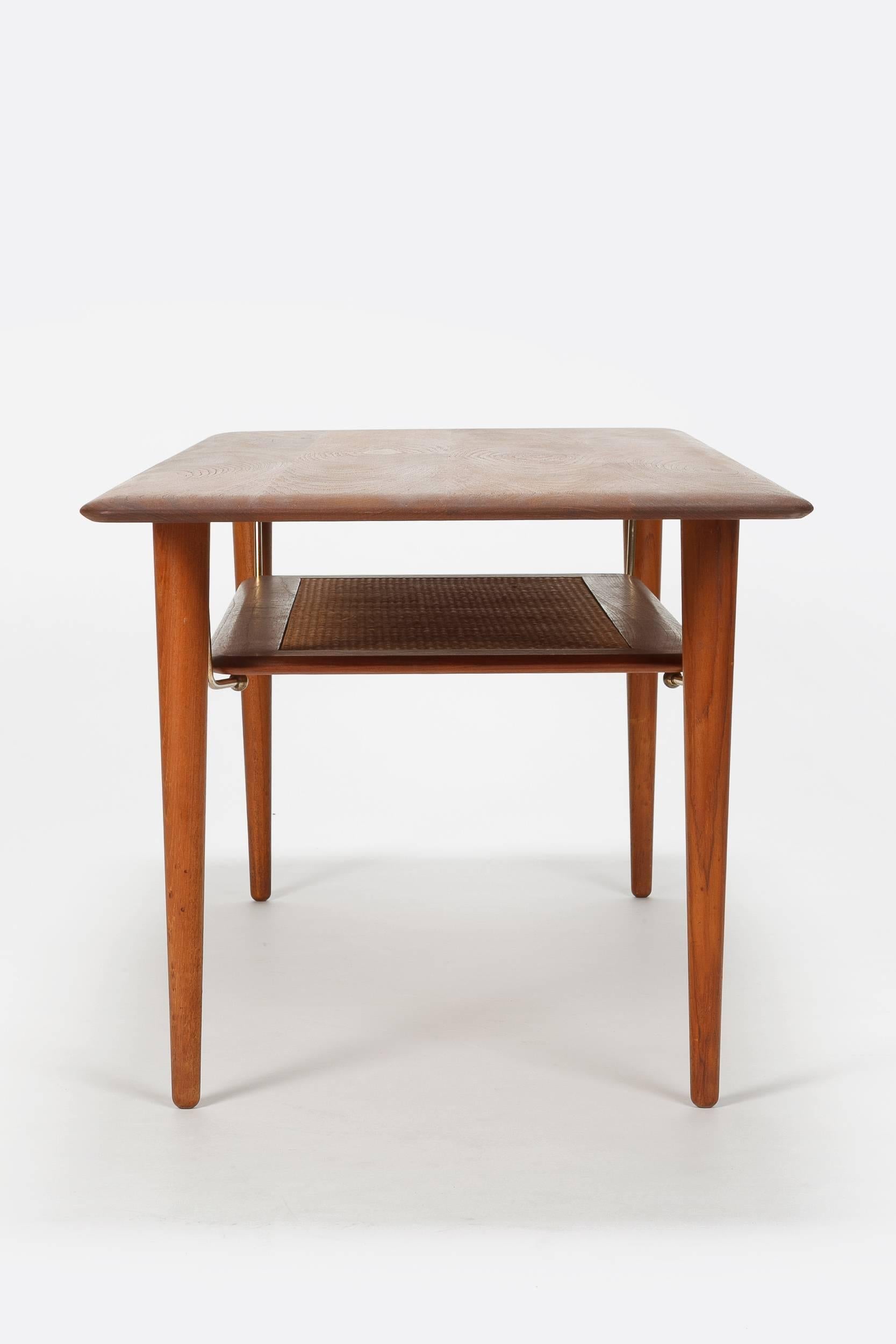 Peter Hvidt & Orla Mølgaard Nielsen coffee table FD 516, manufactured by France & Son in the 1960s in Denmark. High-end coffee table made of teak, with a shelf with teak frame and raffia inlay, beautiful brass fastener. The table has been