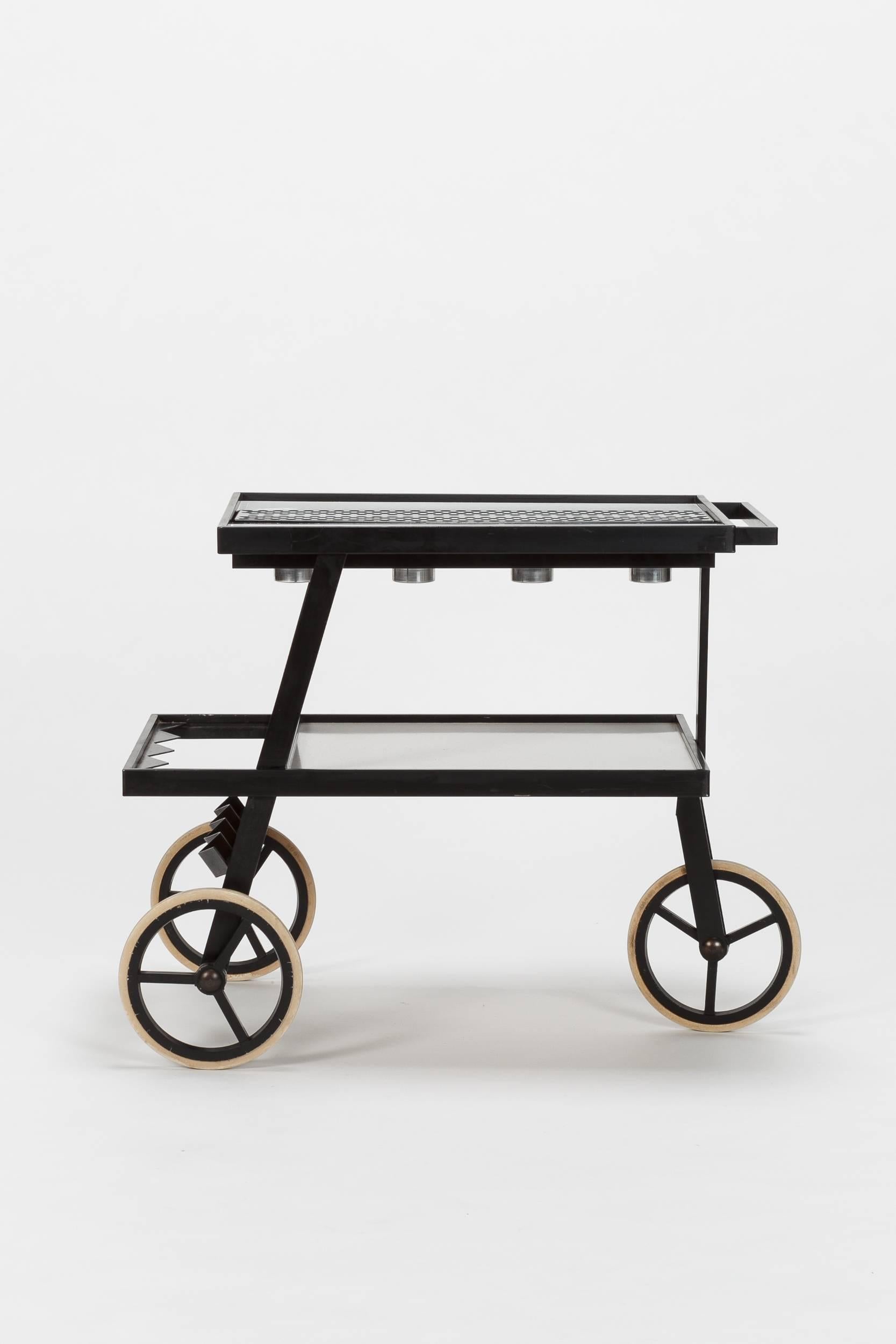 Dutch black and white barcart with rubber wheels, manufactured by Pastoe in the 1970s. The upper shelf is made of Formica inlay and has integrated candleholders made of aluminum and glass. Probably used as a rechaud to keep meals warm. The lower