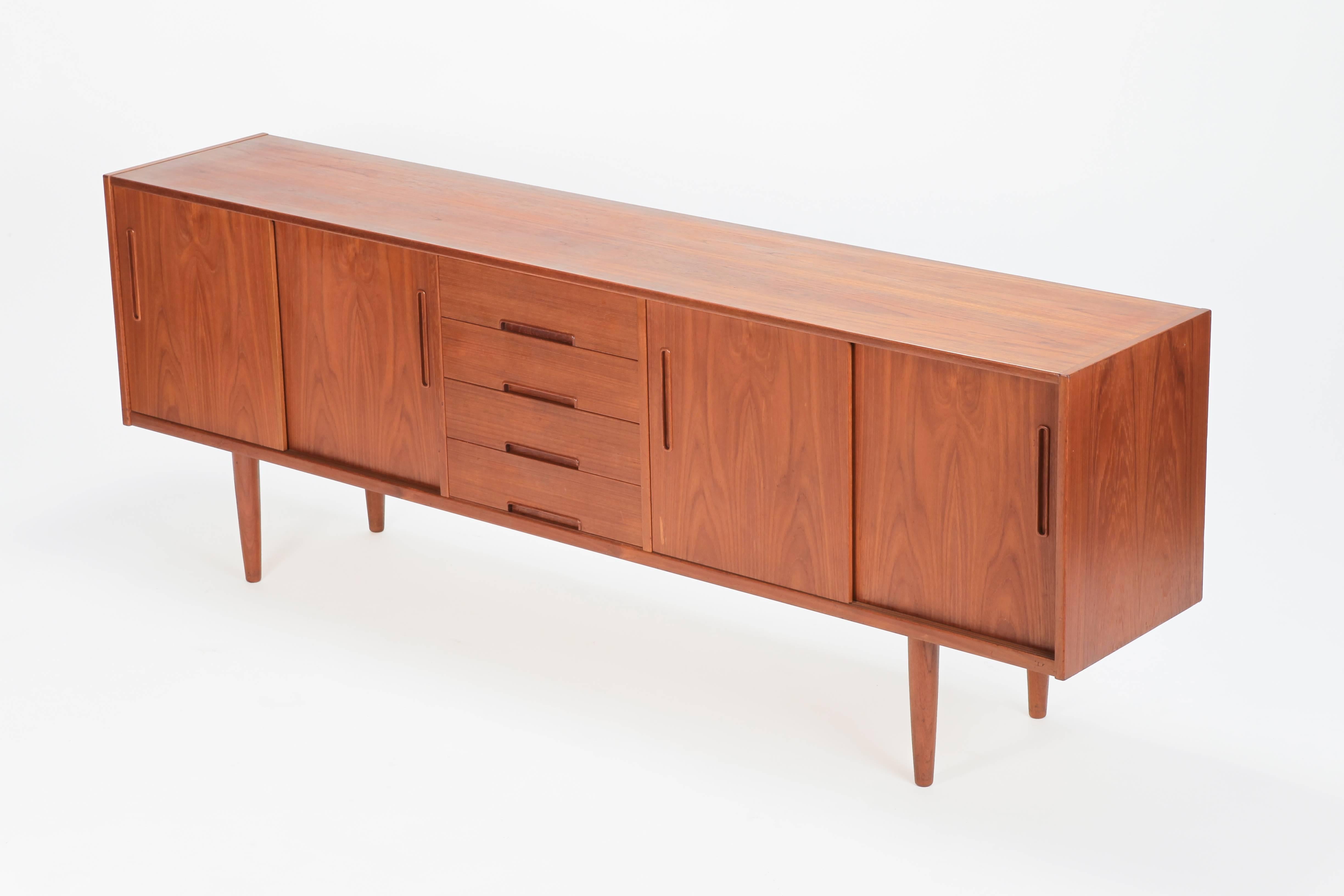 Nils Johnson sideboard manufactured in Sweden by Tores Bjärnum in the 1960s. This sideboard unites much storage and a wonderful timeless Scandinavian design. The board has in the middle four drawers and on both sides there are compartments with