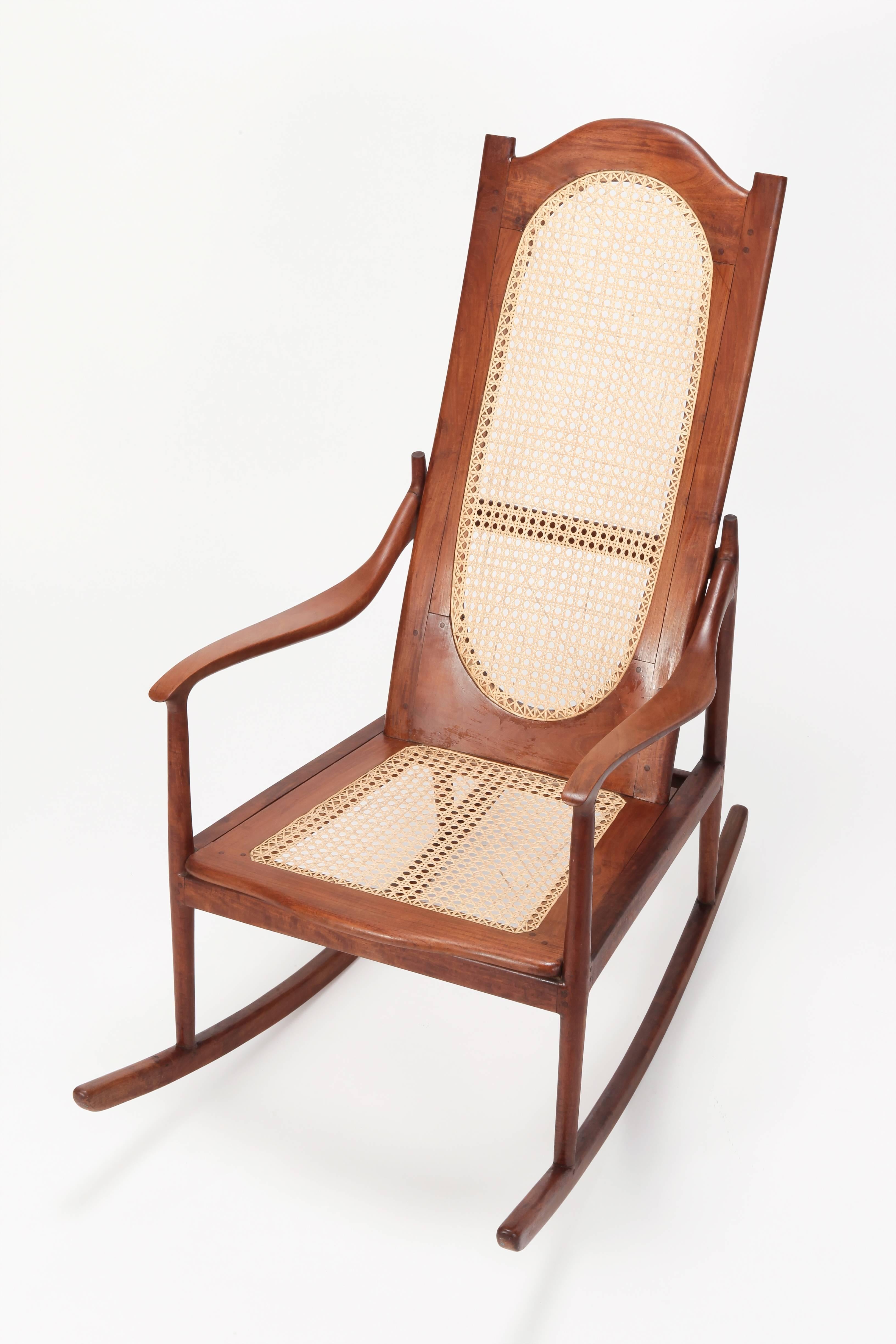 This solid mahogany rocking chair was built with devoted handcraftsmanship in the States in the 1890s. The Jonc seats were carefully renewed. There is no screw on the entire frame, everything is built together with wooden nails. All pieces were
