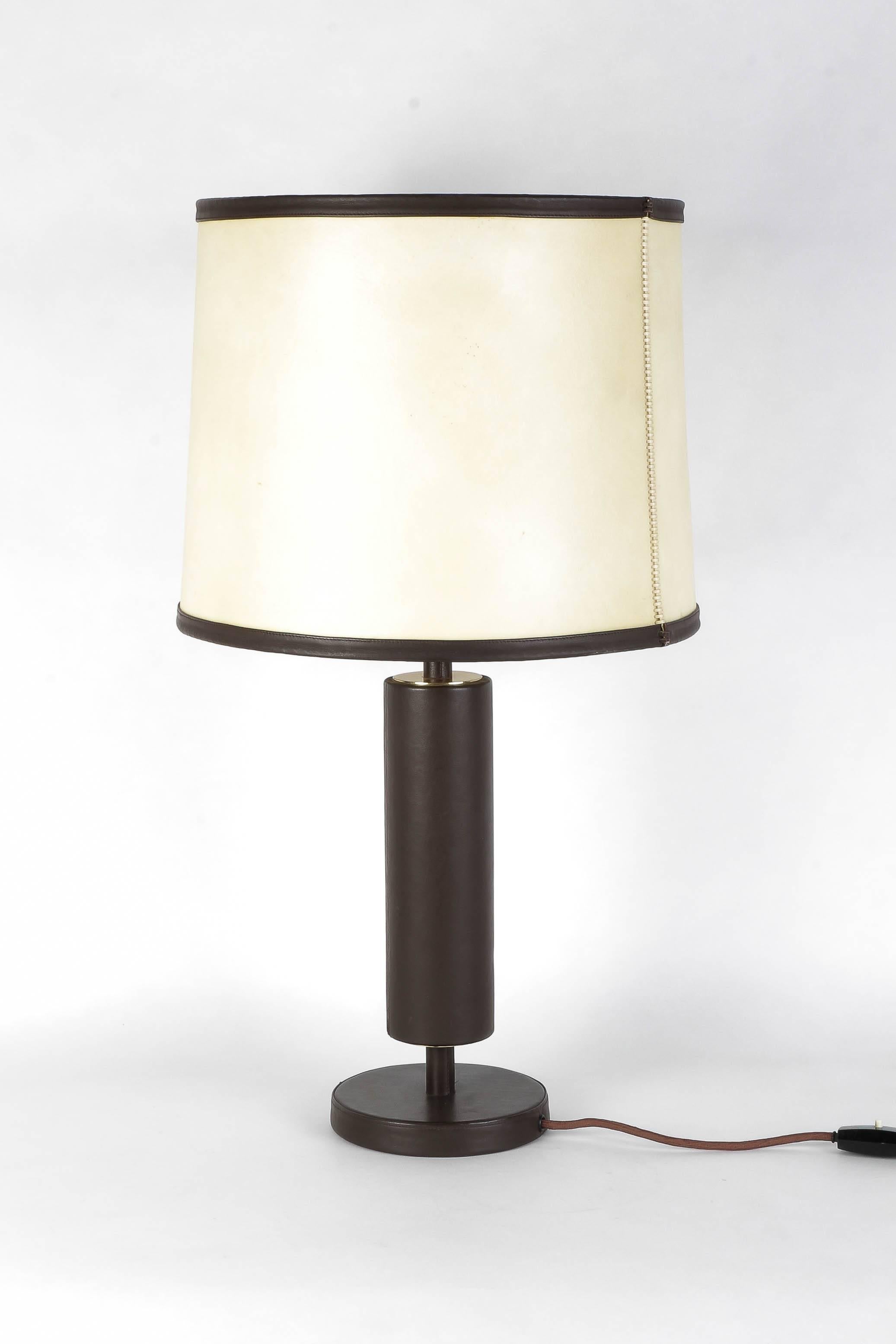 Incredible leather table lamp, manufactured in France in the 1940s. Distributed by Charlotte Wawer in Germany. Leather covered base and stem with a brass panel on border, the lampshade is made of look alike animal skin, fibre sprayed paper like