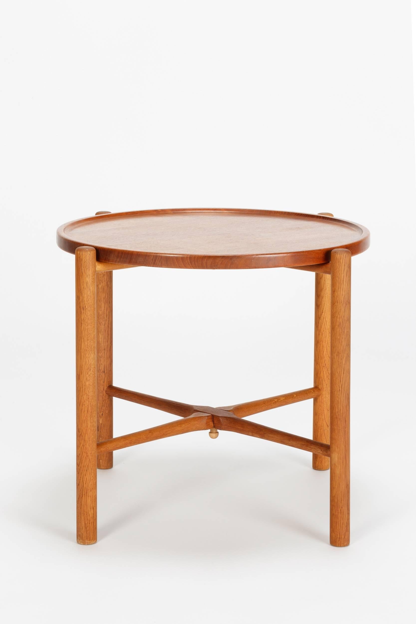 Very practical Hans Wegner folding table model AT-35, designed in 1945 and manufactured  by Andreas Tuck in Denmark in the 1950's. The top tray is made of solid teak wood, the oak base is foldable. Stamped to underside with manufacturers label.