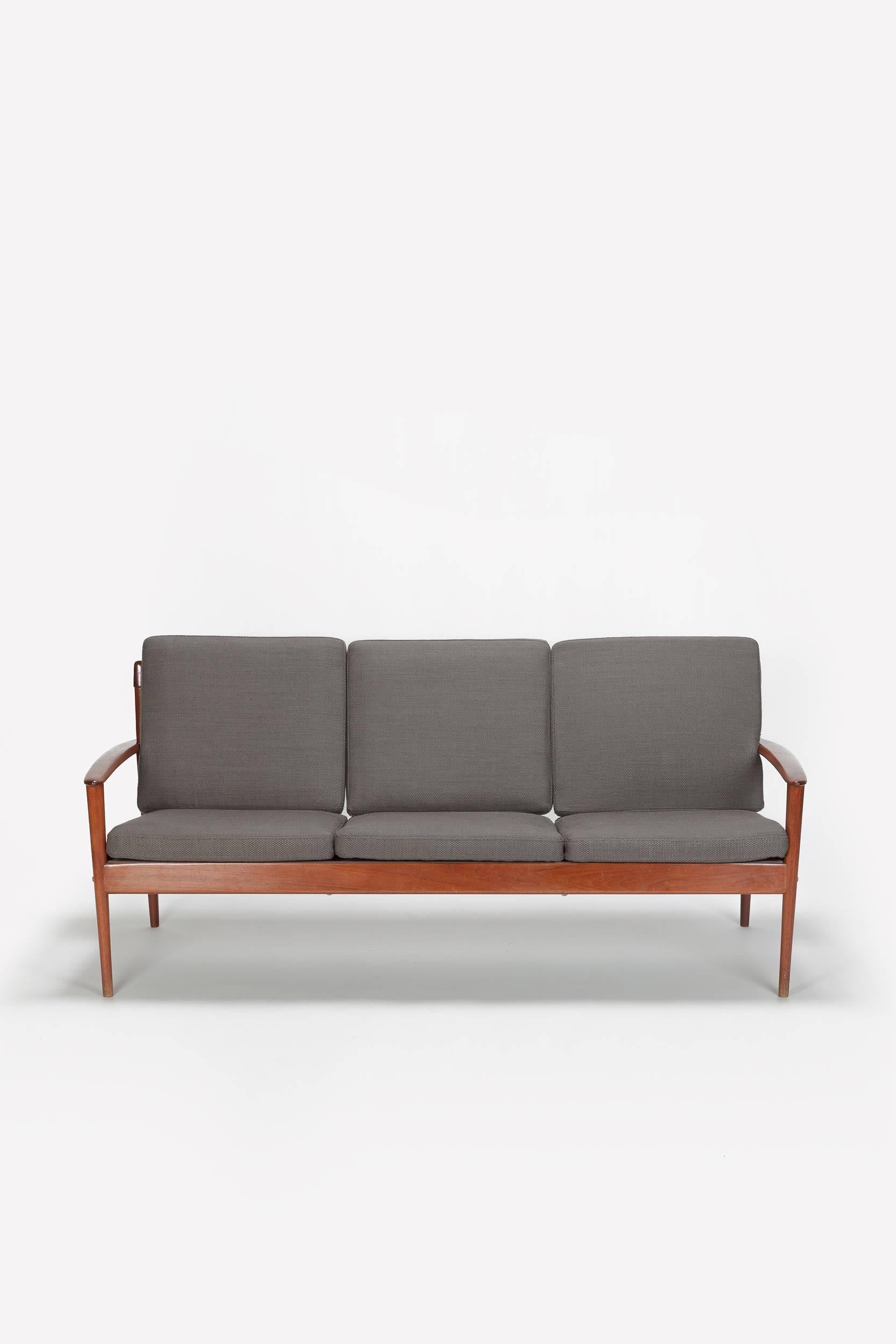An early example of the Grete Jalk sofa model PJ 56/3 manufactured by P. Jeppesen in Denmark in the late 1950s. Solid and sophisticated teakwood frame with beautiful details, the back spears through the armrests. This wonderful detail was later