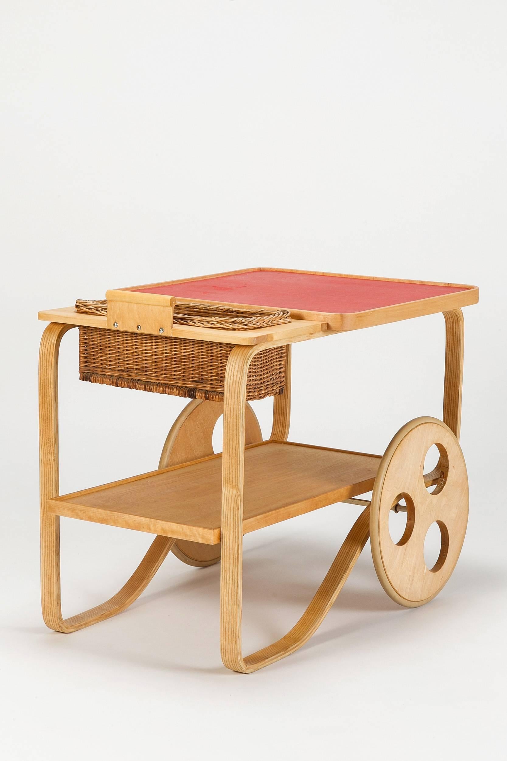 Incredibly rare bar cart or serving trolley by Alvar Aalto for Wohnbedarf Zurich, Switzerland in 1937. Made of solid birch and birch plywood, red linoleum surface with a removable wicker basket, Rubber coated wheels. 