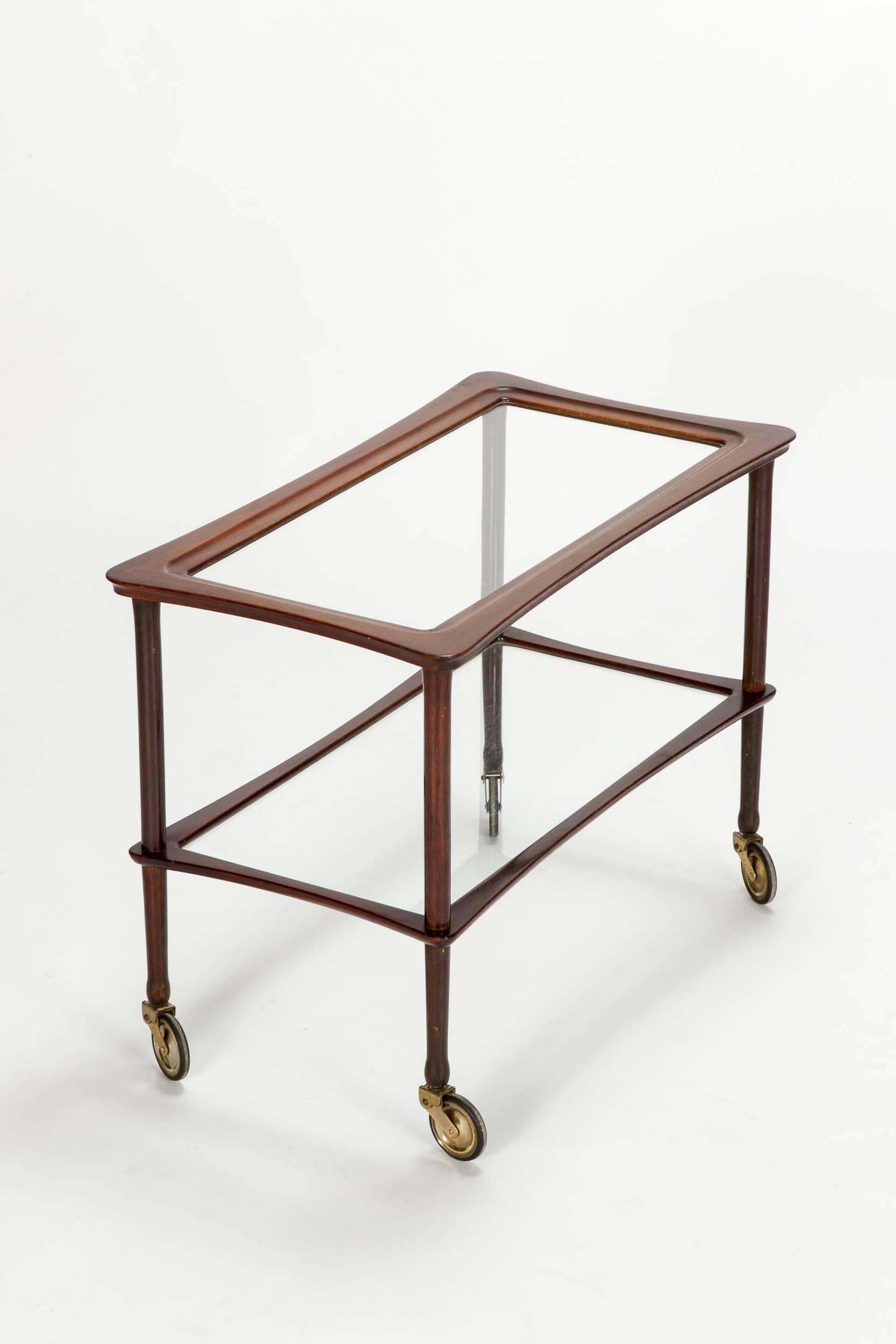 Wonderful and organically shaped Italian bar cart by Cesare Lacca made of mahogany and glass, Italy in the 1950s. Filigree form with beautiful crafted details.