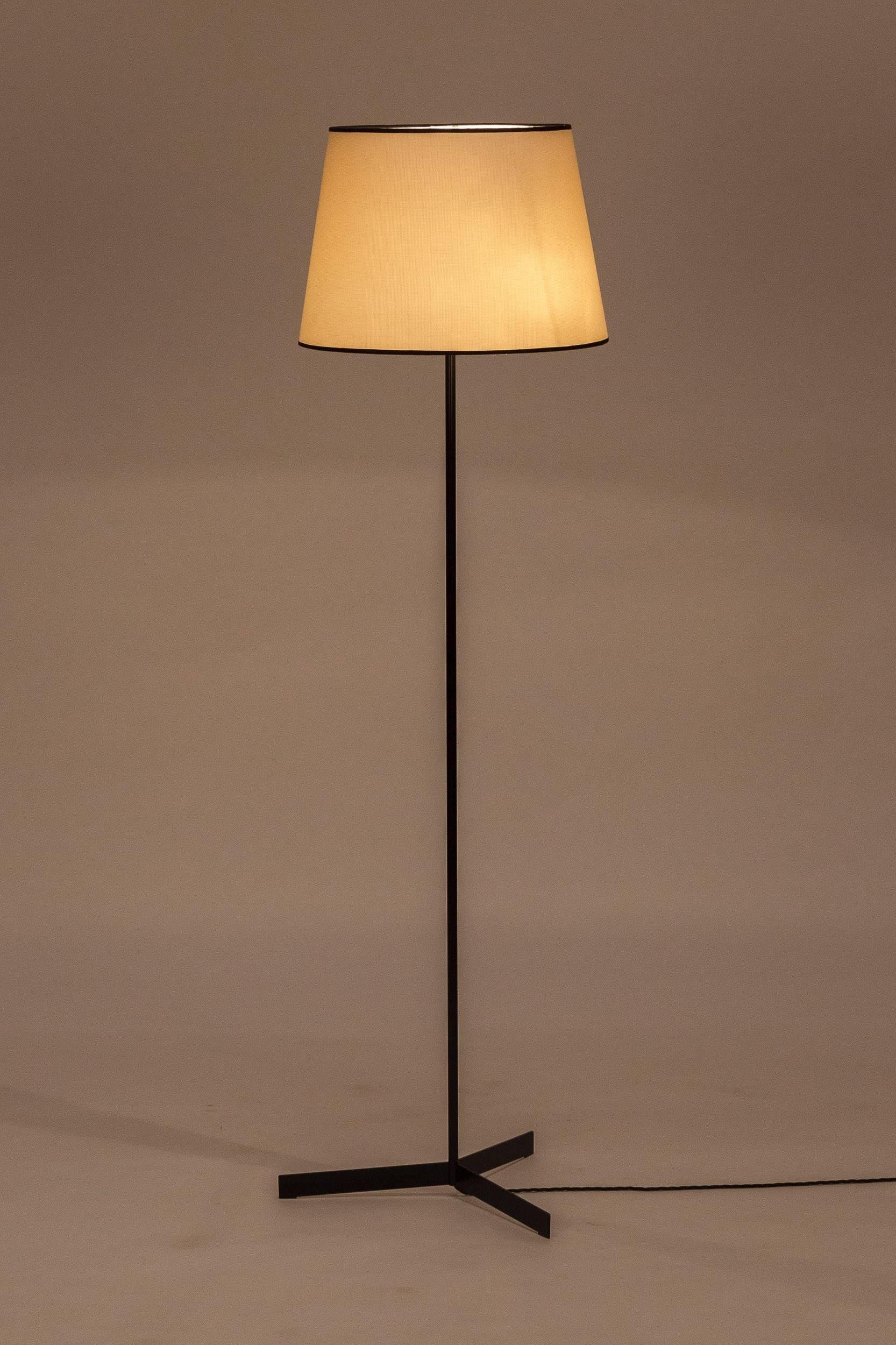 Tripodal floor lamp manufactured in the 1960s in France. Original stem made of lacquered tubular steel, new shade made of cotton fabric on original frame, very decorative black ribbon on the border. Separate switch for uplight and downlight, newly