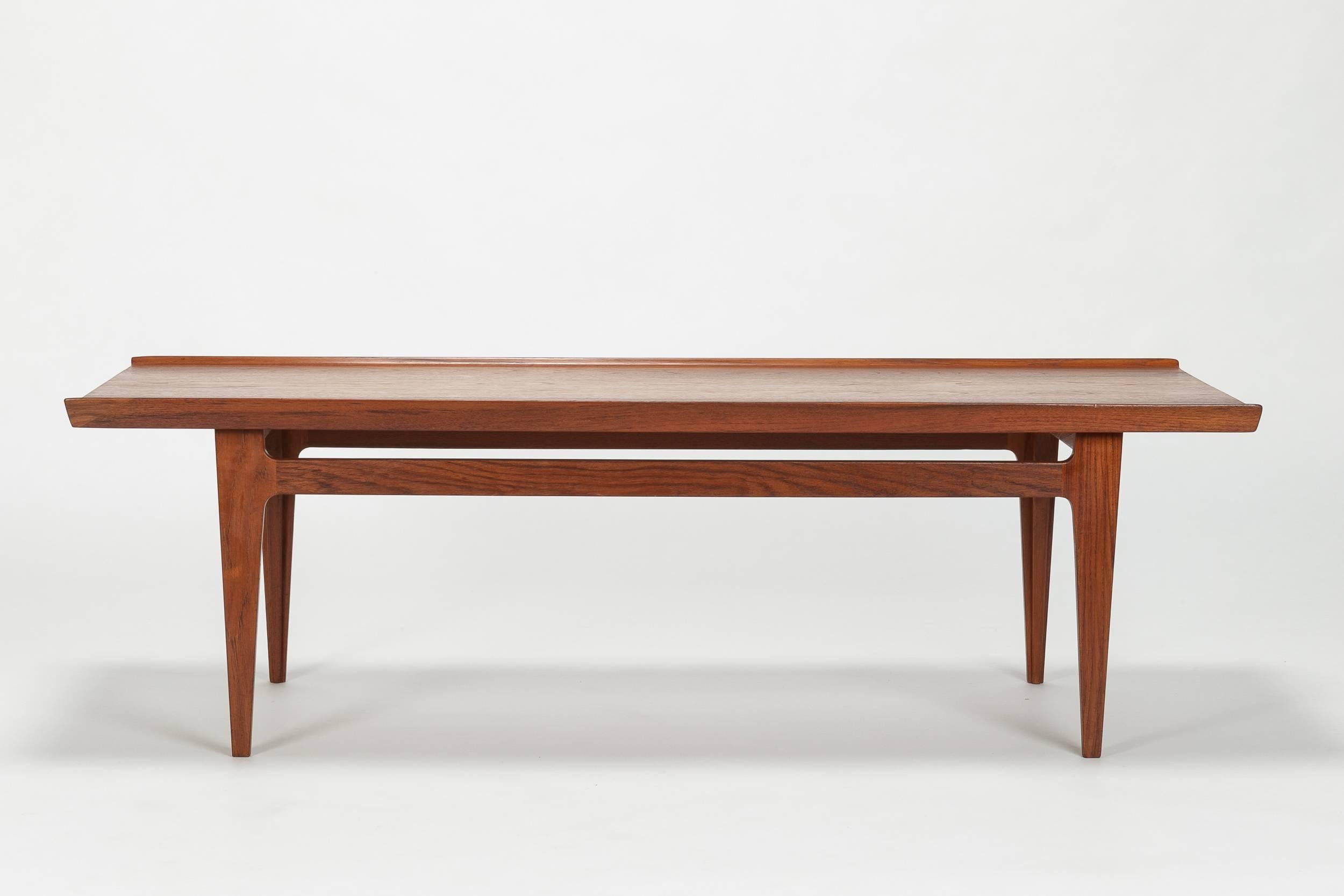 Stunning Finn Juhl coffee table manufactured by France & Son in Denmark in the 1950s. Made of solid teak wood. A particular detail is the raised edge to ensure nothing rolls off of the table.