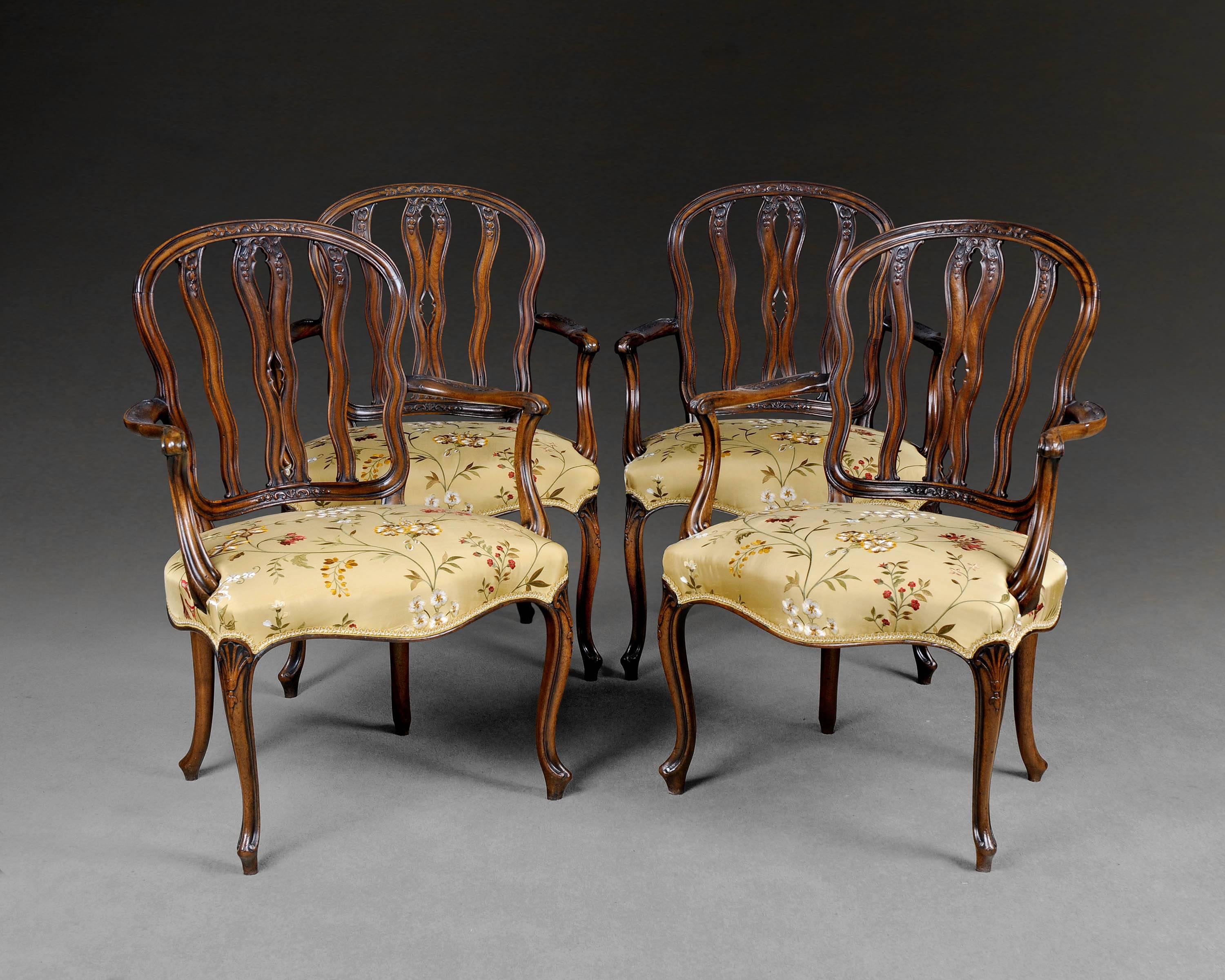 An important set of four Hepplewhite period mahogany salon armchairs. The cartouche shaped carved backs with wavy carved uprights flanked by carved shaped scrolling arms and raised on extremely fine carved cabriole legs.

One from this set of