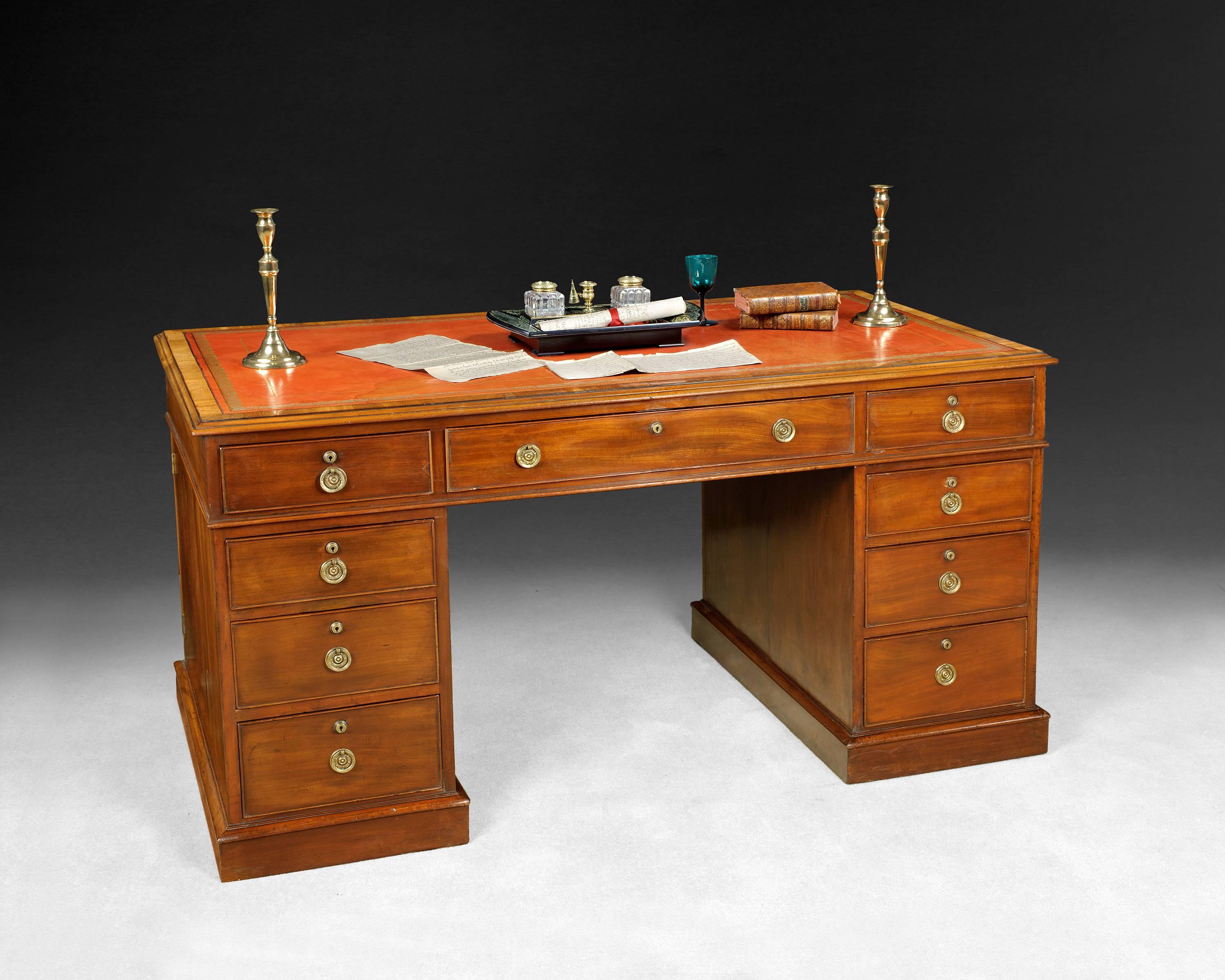 A good William IV period mahogany partners pedestal desk, the top with a red gilt tooled and crossbanded leather panel and three frieze drawers to one side and three false drawers to the other, the pedestals both with three graduated drawers and
